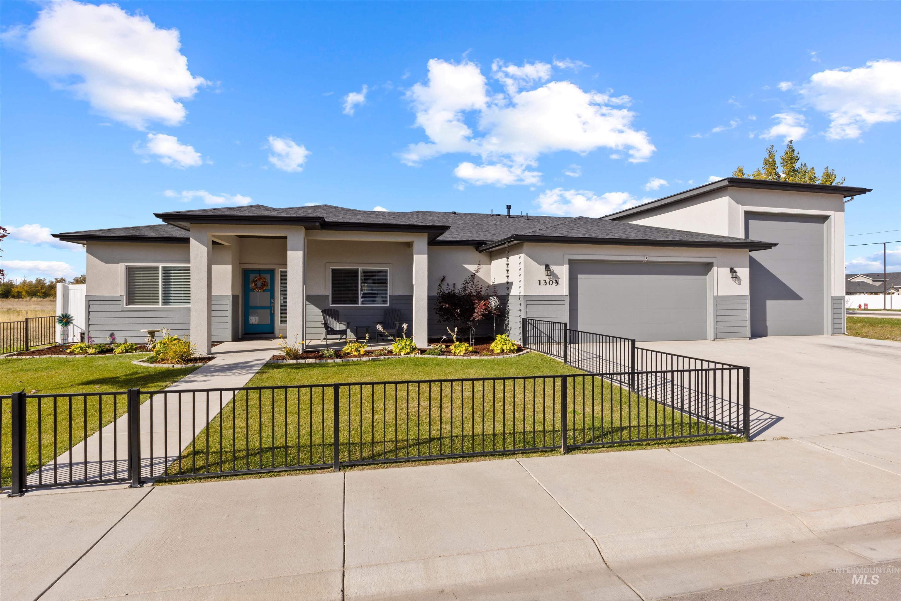 View of front facade featuring covered porch, a garage, concrete driveway, stucco siding, and a shingled roof