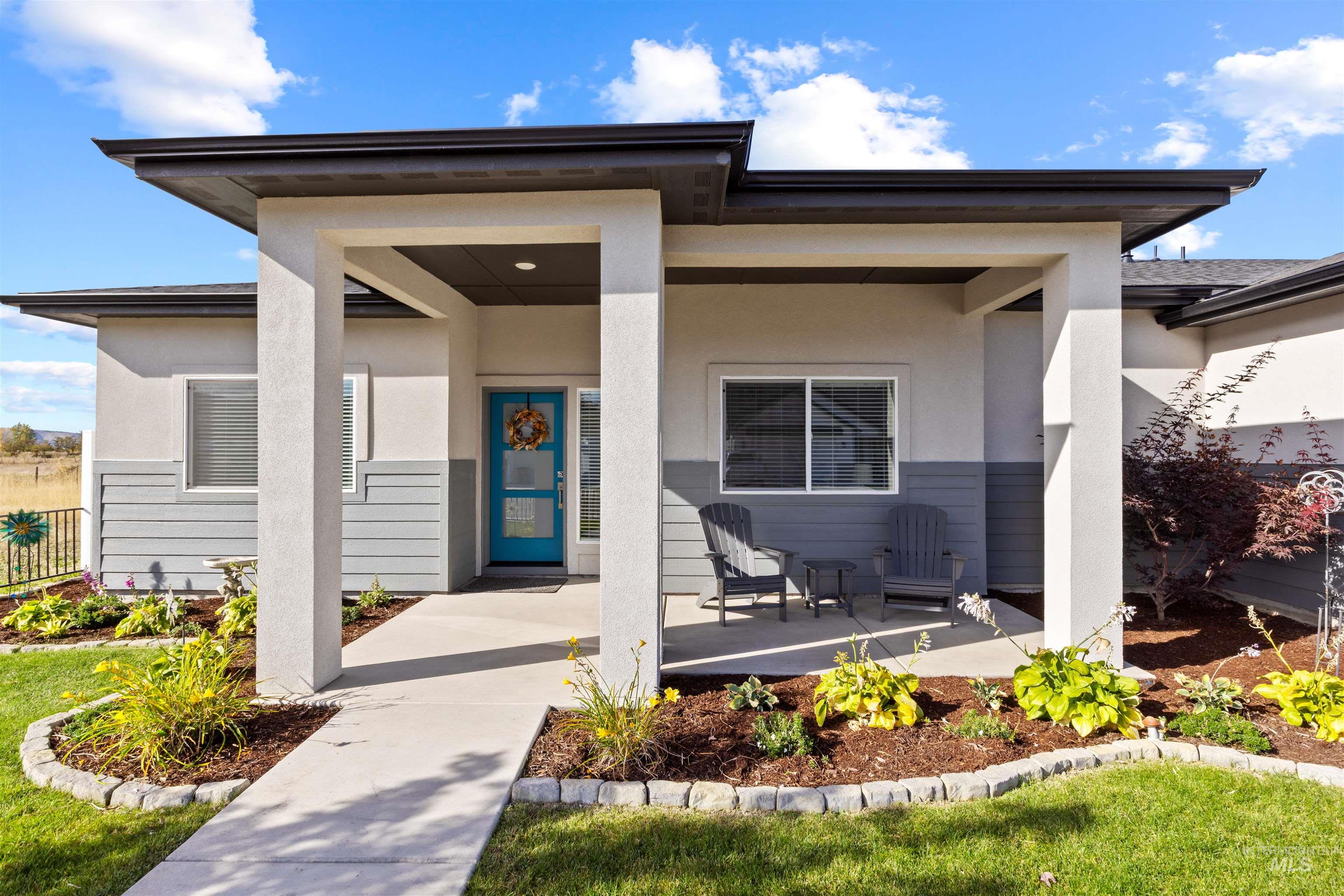 View of exterior entry featuring covered porch and stucco siding