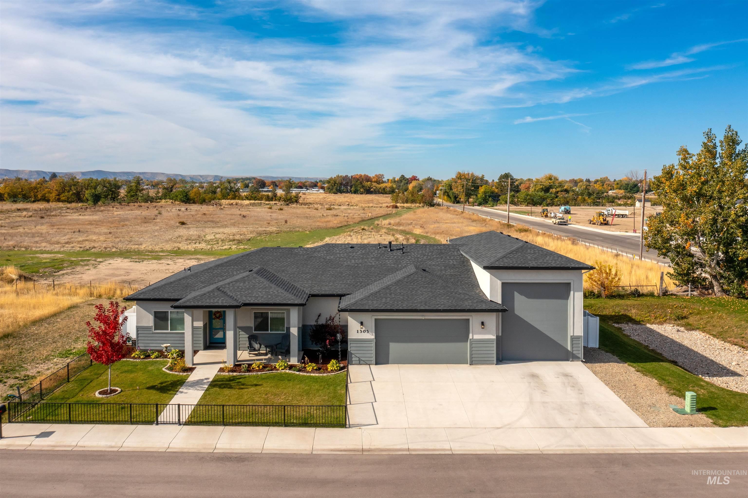 View of front facade with roof with shingles, a fenced front yard, a garage, and concrete driveway