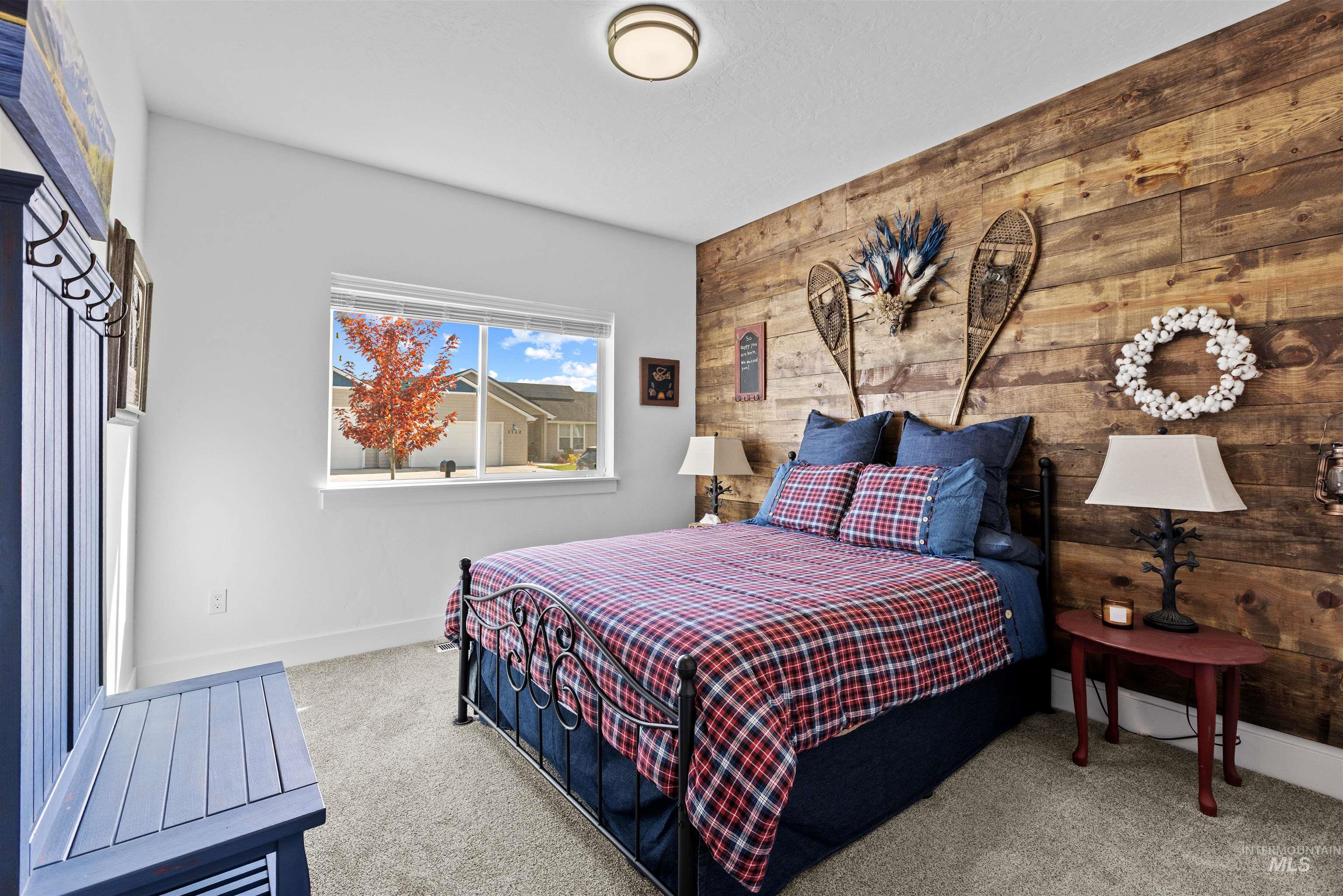 Carpeted bedroom featuring wood walls and an accent wall