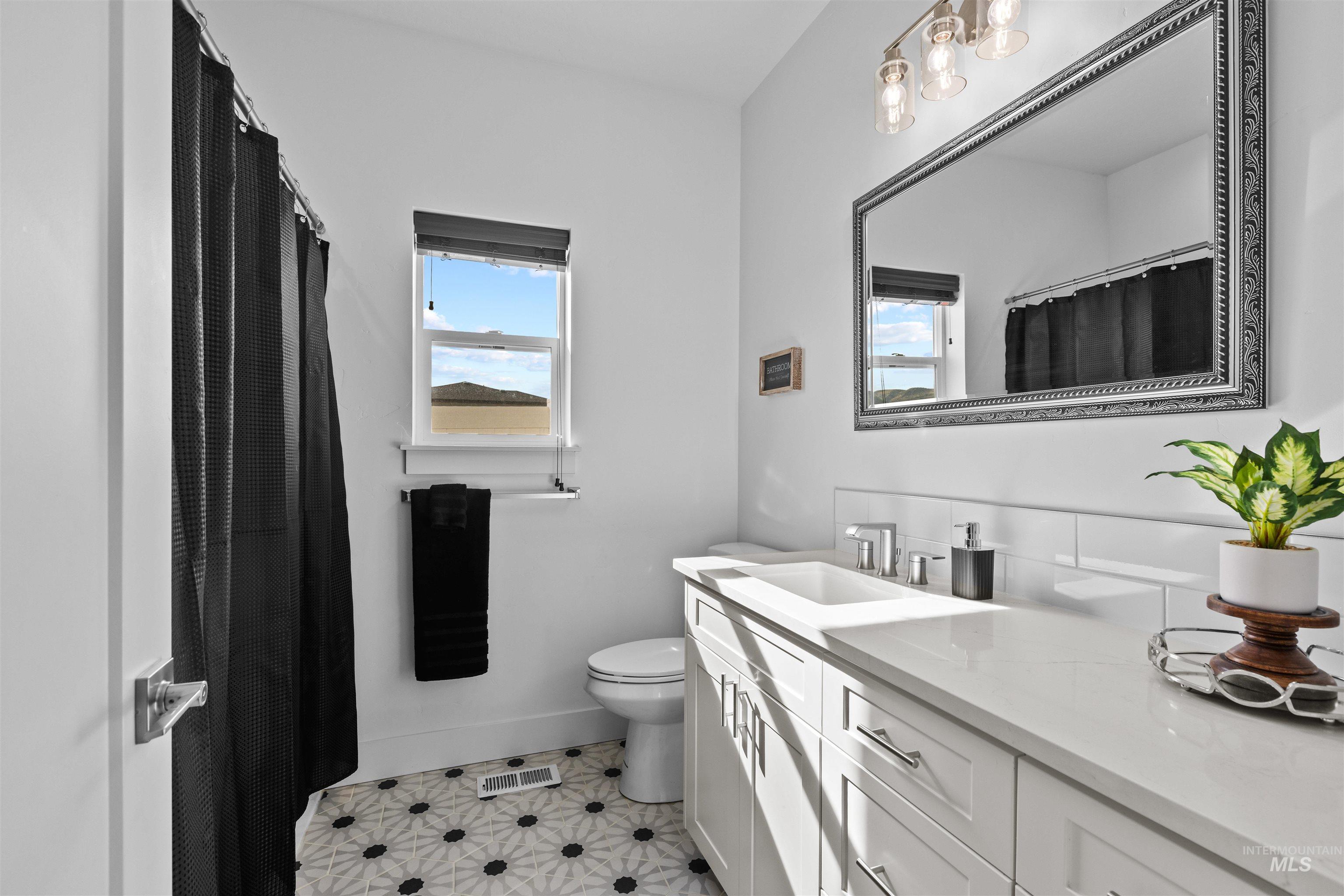 Bathroom featuring a shower with curtain, vanity, and light tile patterned floors