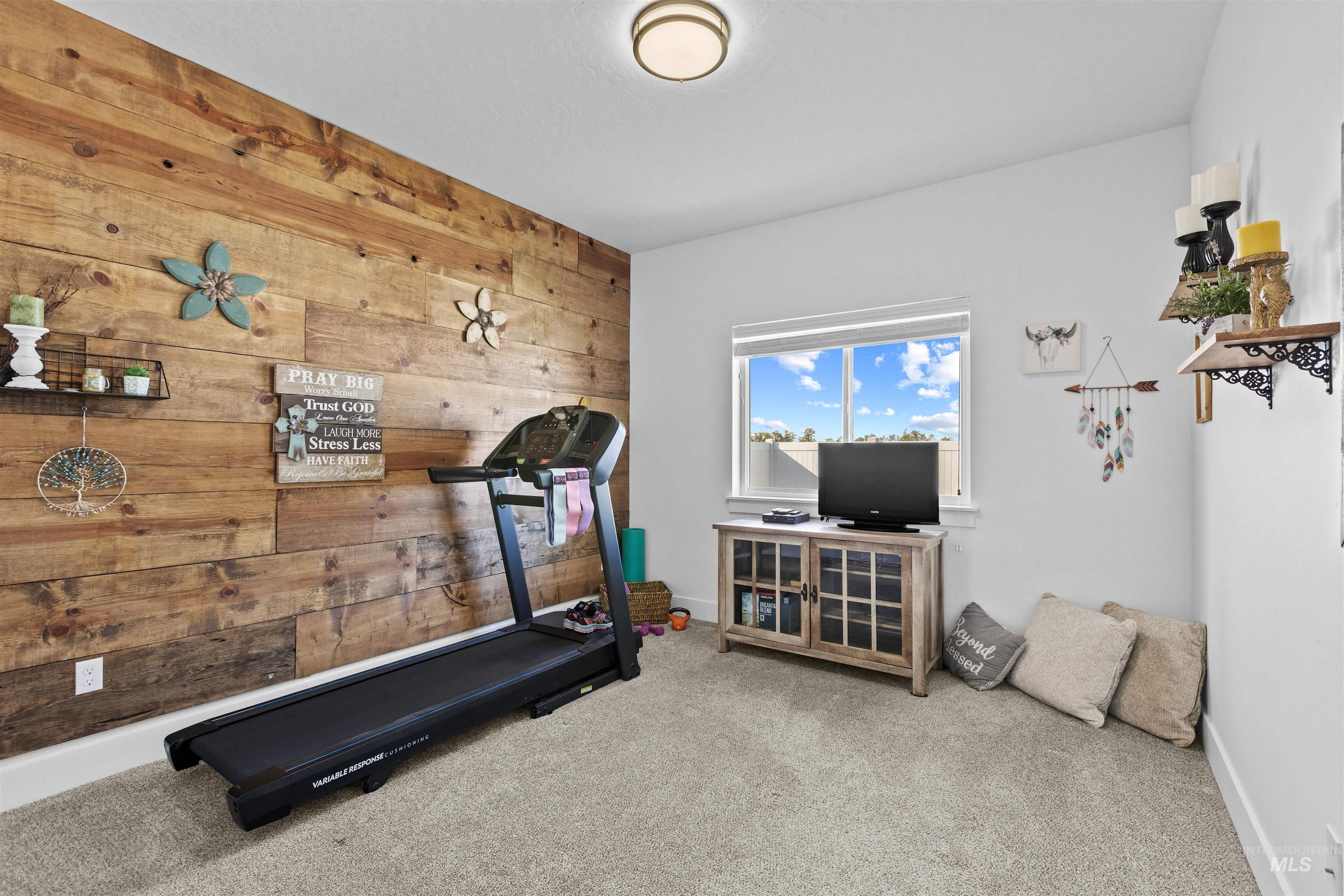 Workout room featuring wood walls and carpet flooring