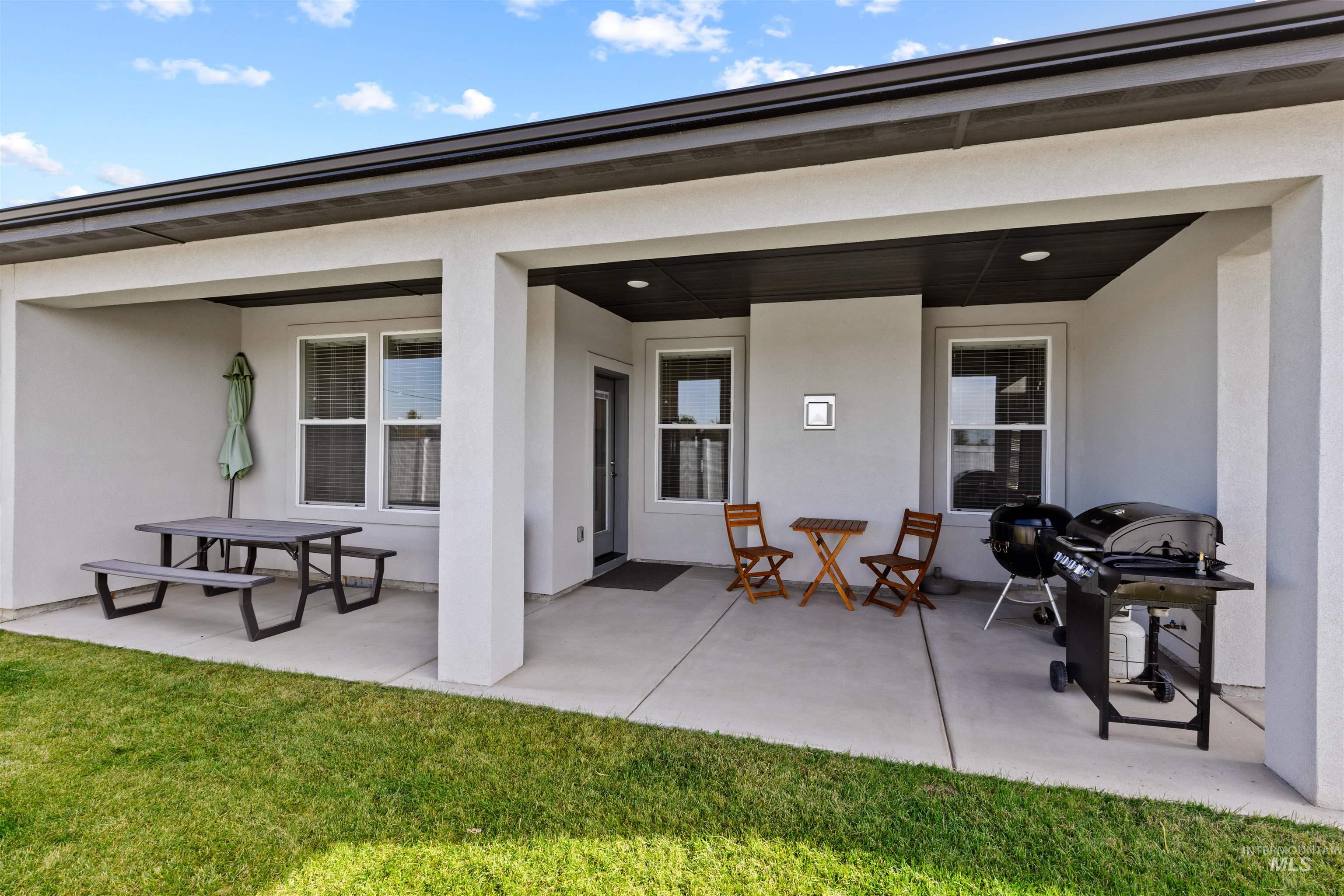 Rear view of property with stucco siding, a patio area, and outdoor dining area
