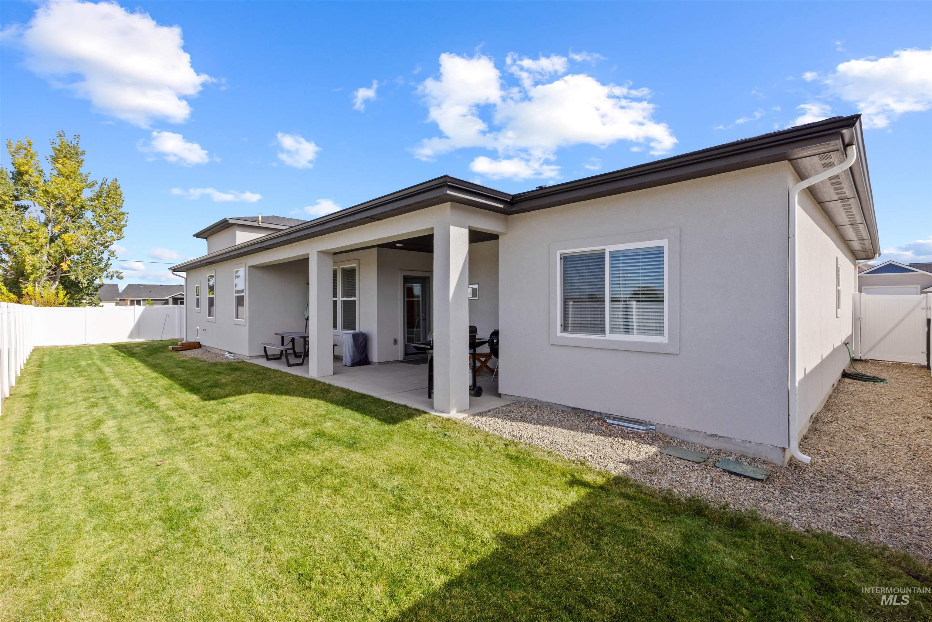 Back of house with a fenced backyard, a patio, and stucco siding