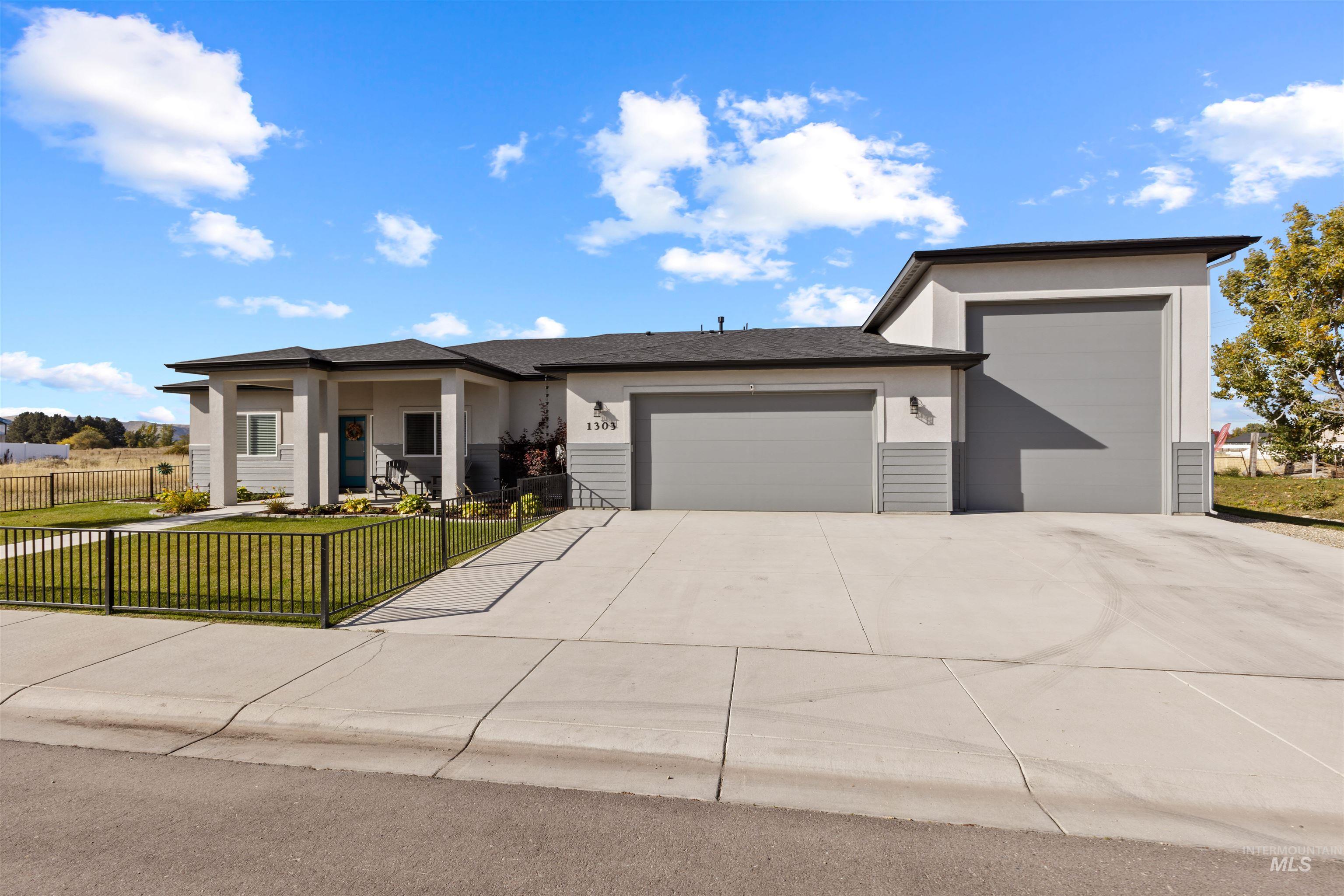 View of front facade featuring stucco siding, a garage, covered porch, and concrete driveway