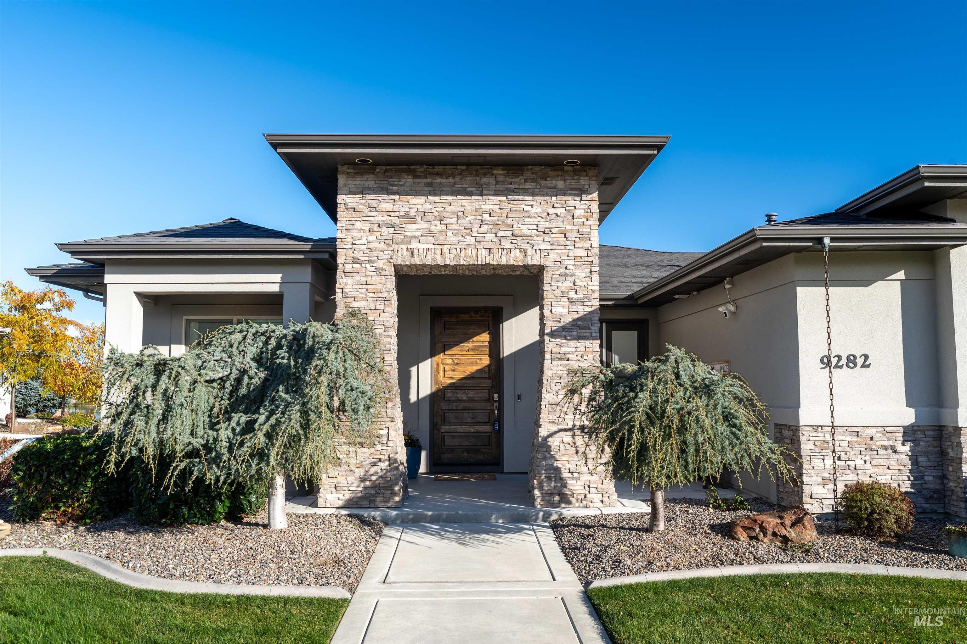 Doorway to property with stone siding and stucco siding