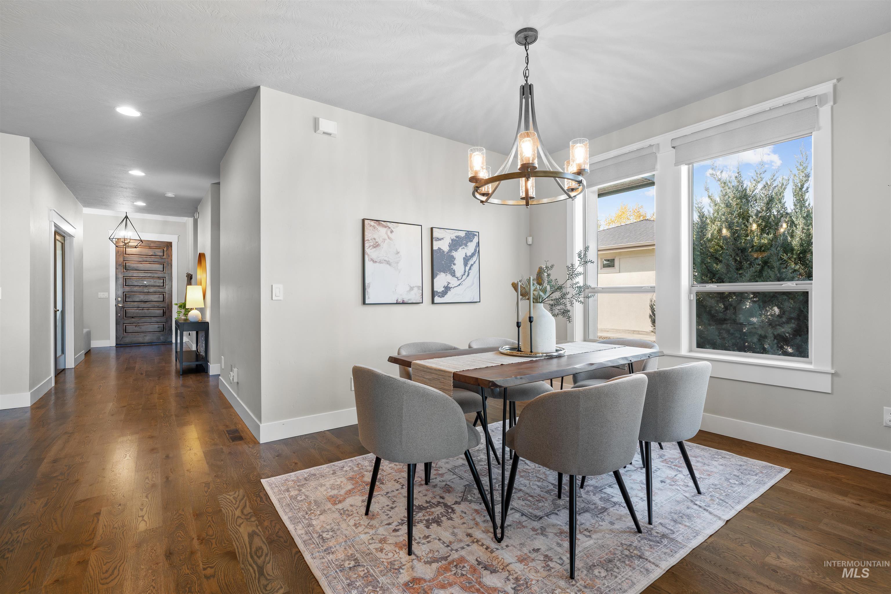 Dining room with a chandelier, dark wood-style floors, and recessed lighting
