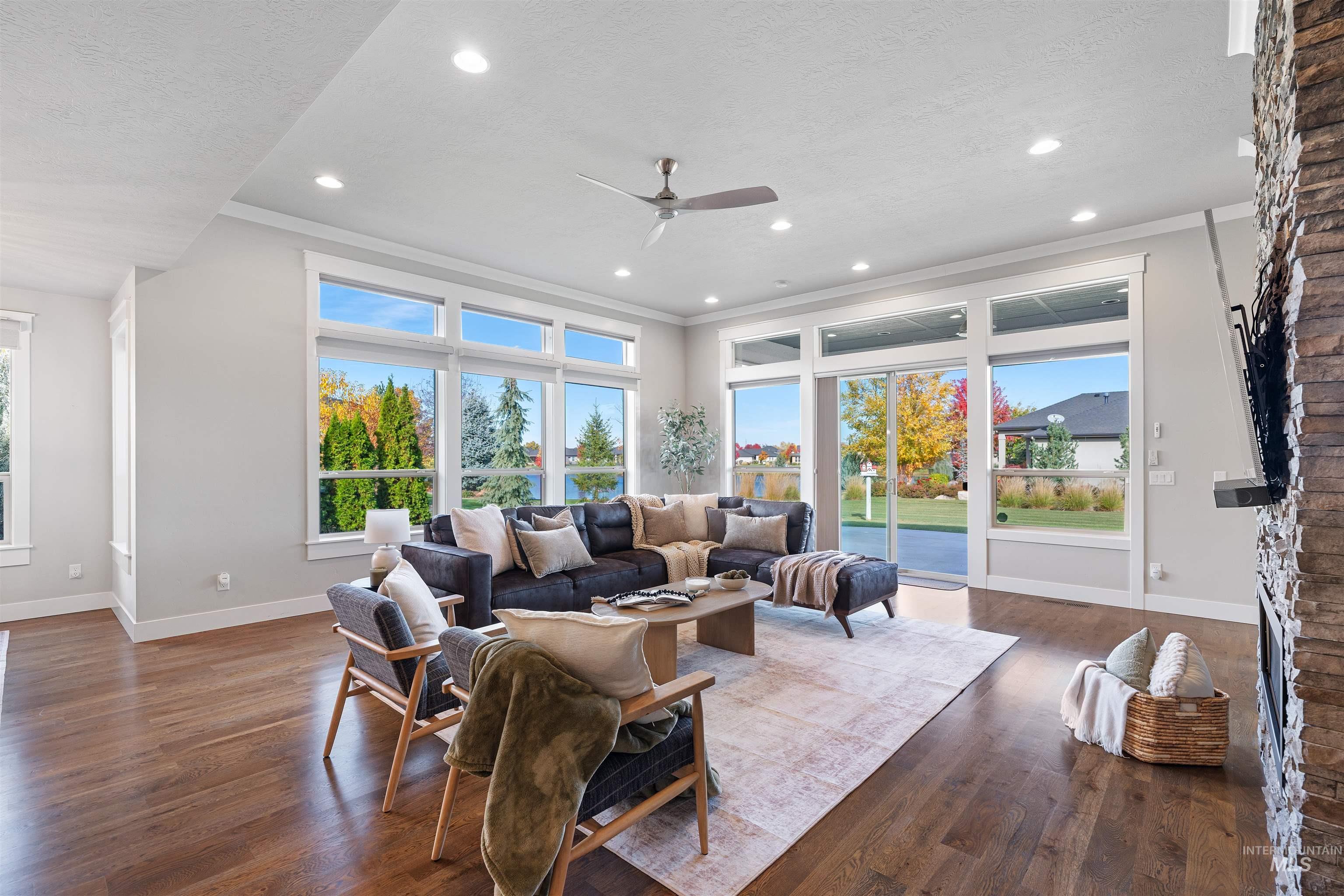 Living area with dark wood finished floors, a textured ceiling, a ceiling fan, recessed lighting, and a fireplace
