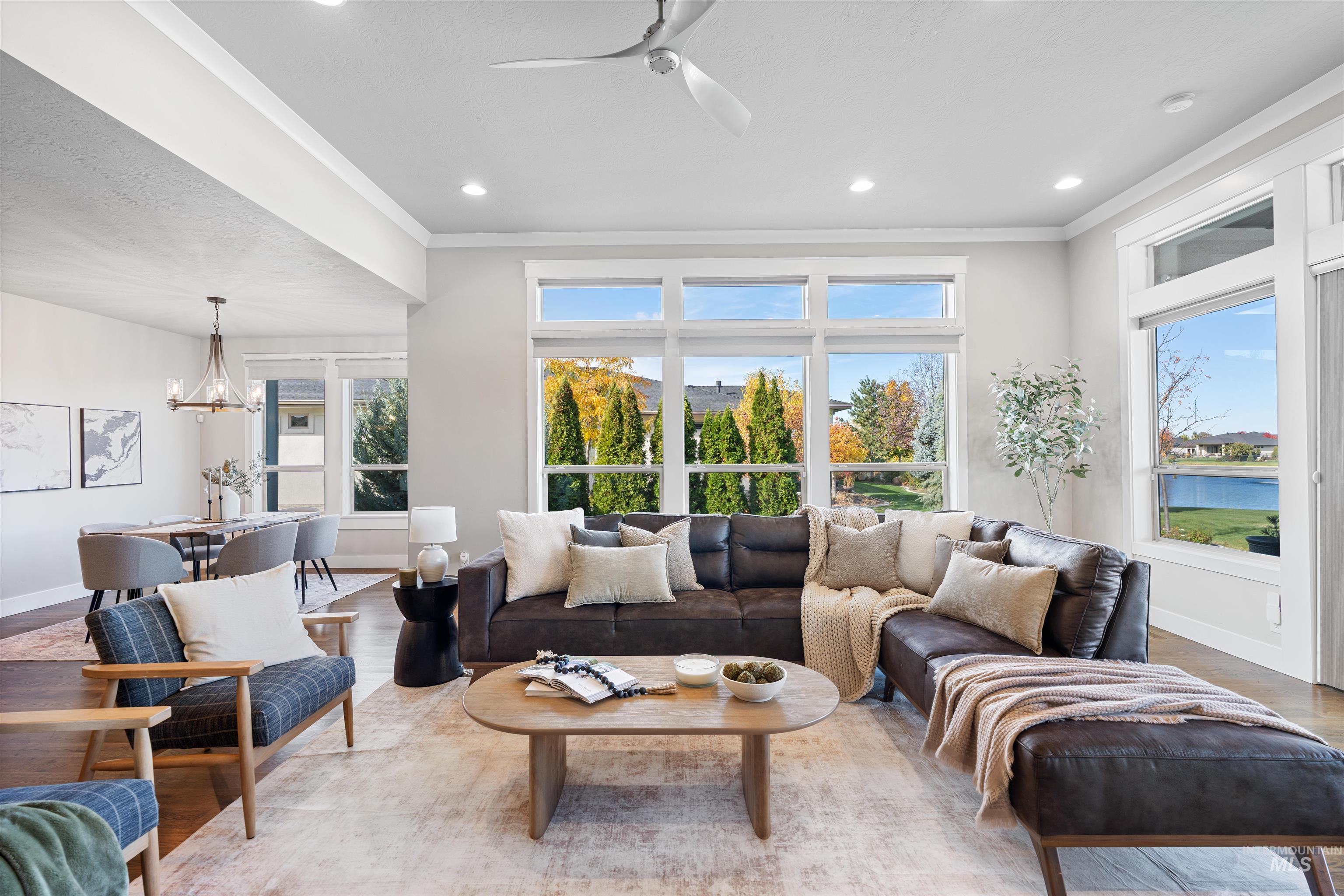 Living area featuring wood finished floors, crown molding, a chandelier, recessed lighting, and a ceiling fan