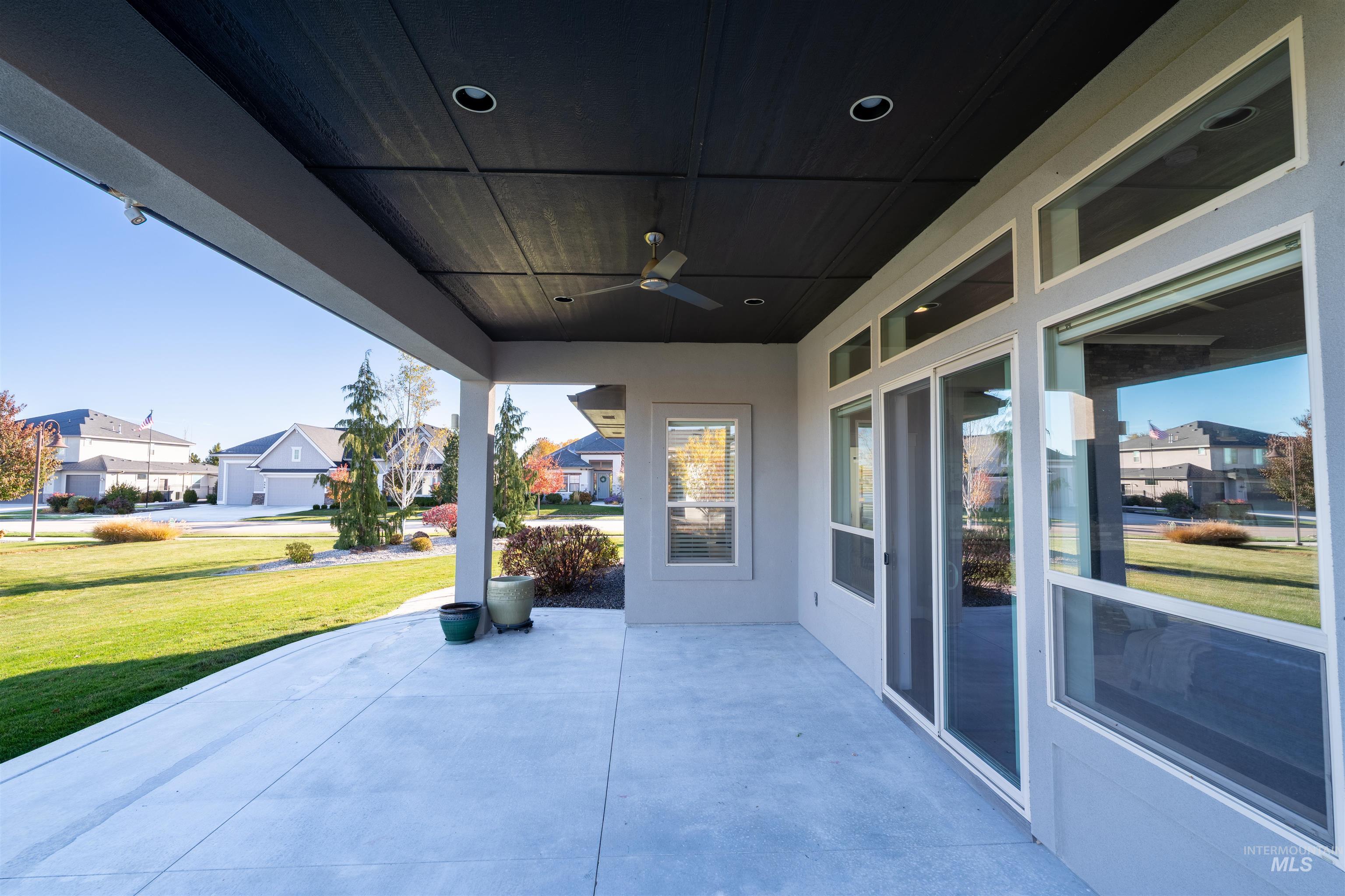 View of patio / terrace with ceiling fan and a residential view