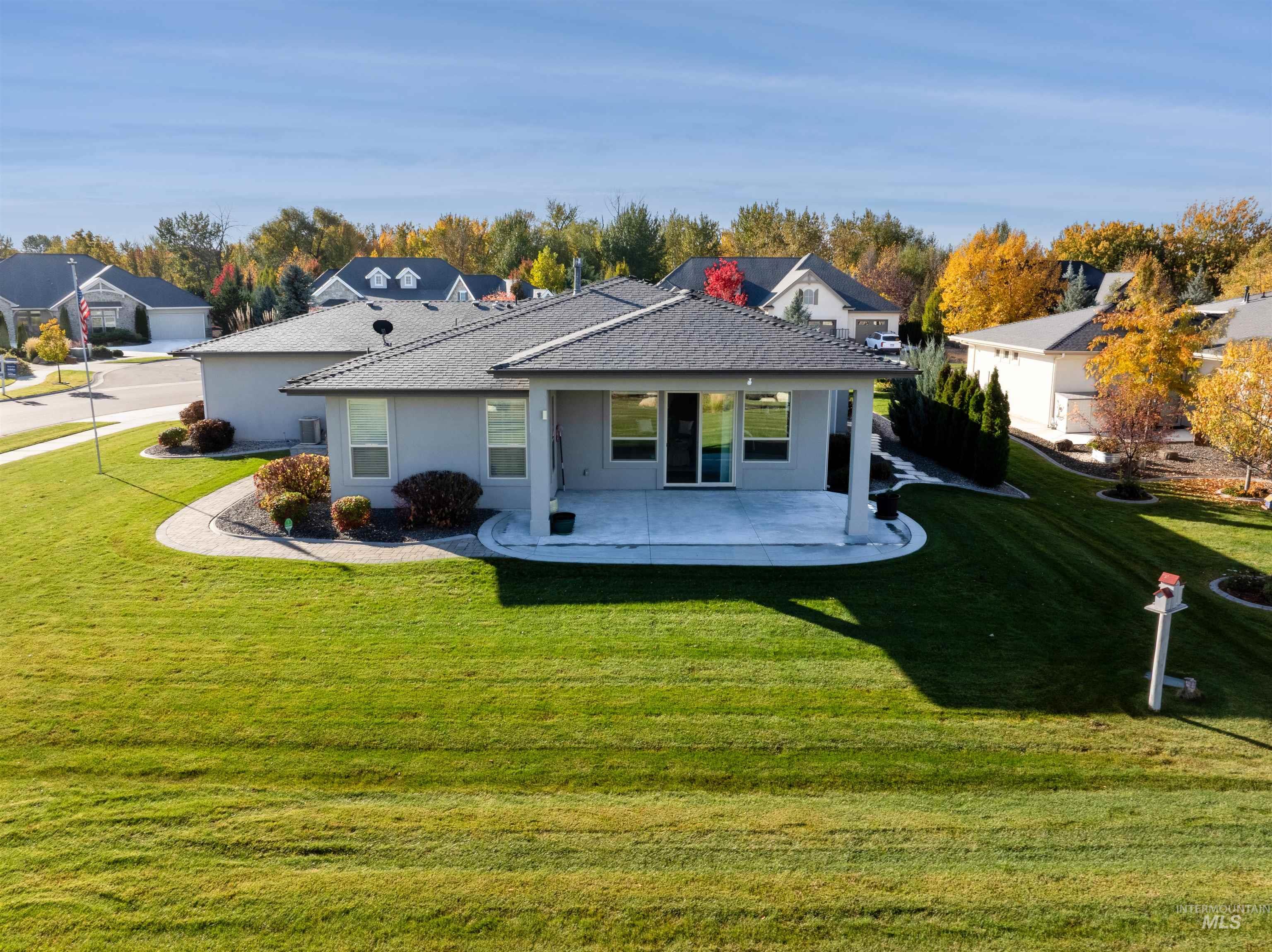 Back of house featuring a lawn, stucco siding, and a patio