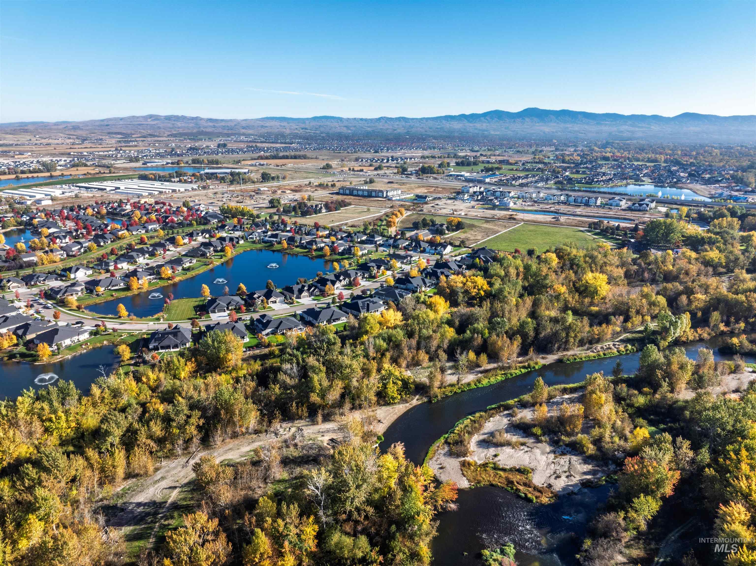 Aerial view of property and surrounding area featuring a water and mountain view