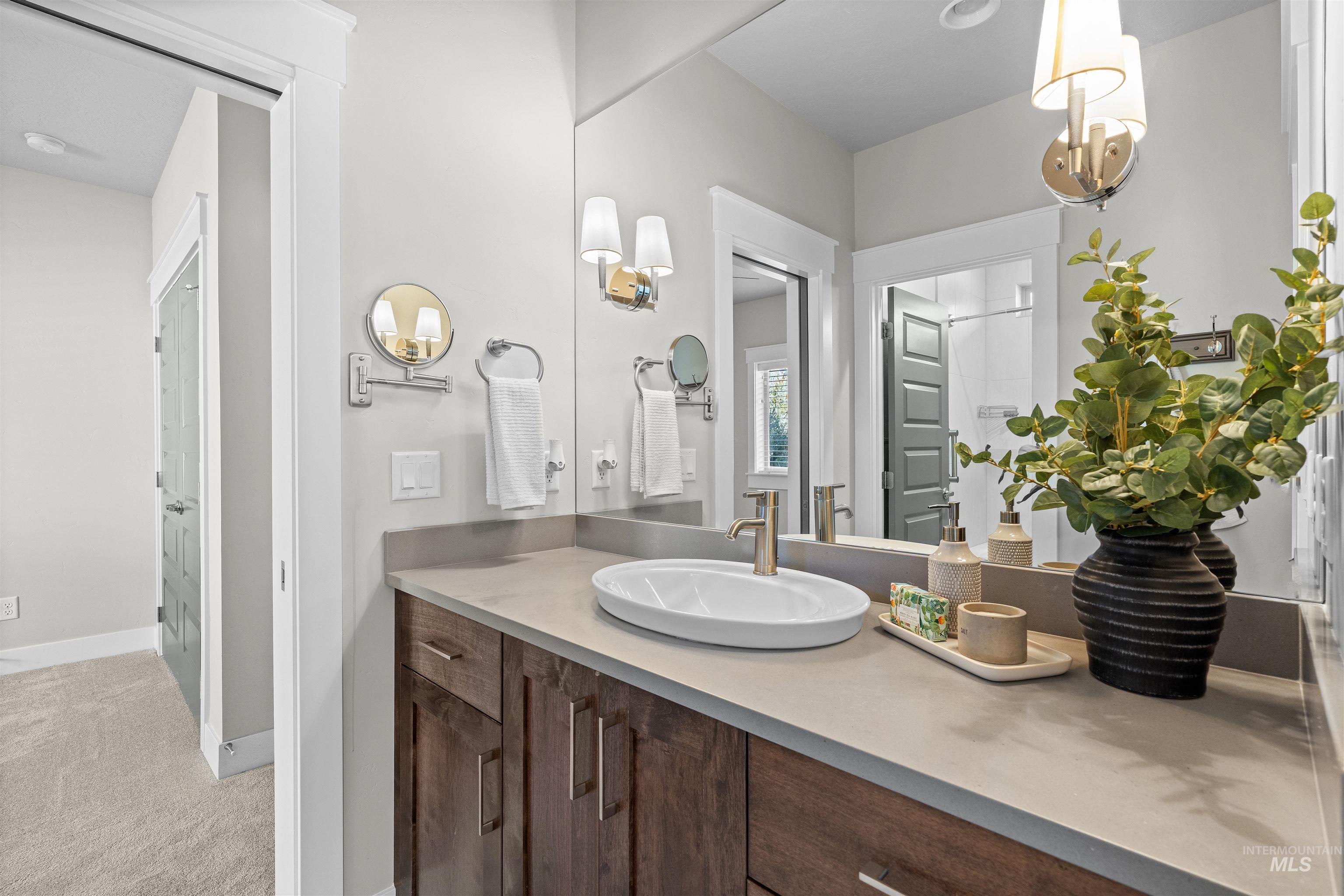 Bathroom with vanity and light carpet