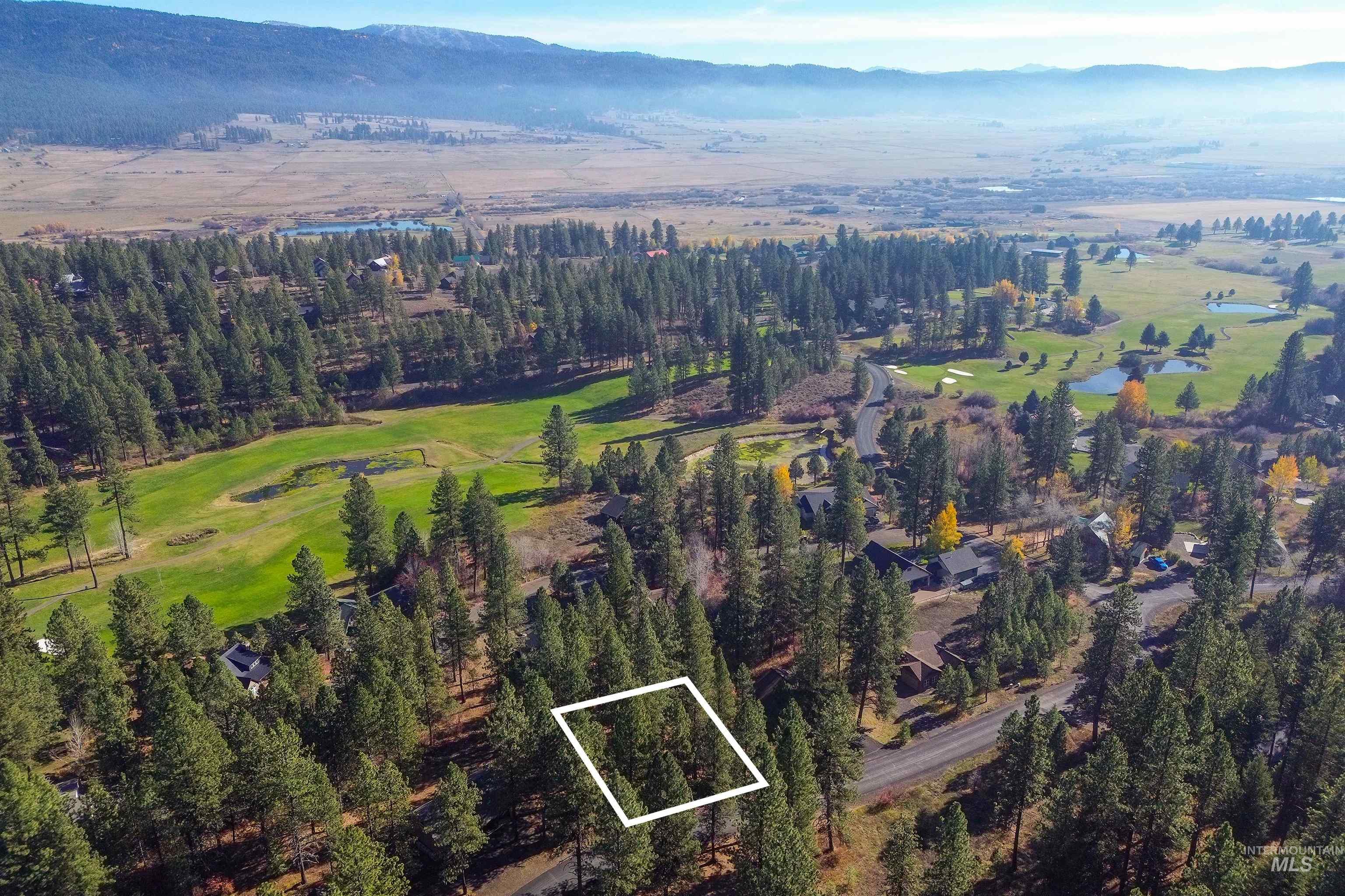 Aerial view of property and surrounding area with property boundaries highlighted and a mountainous background