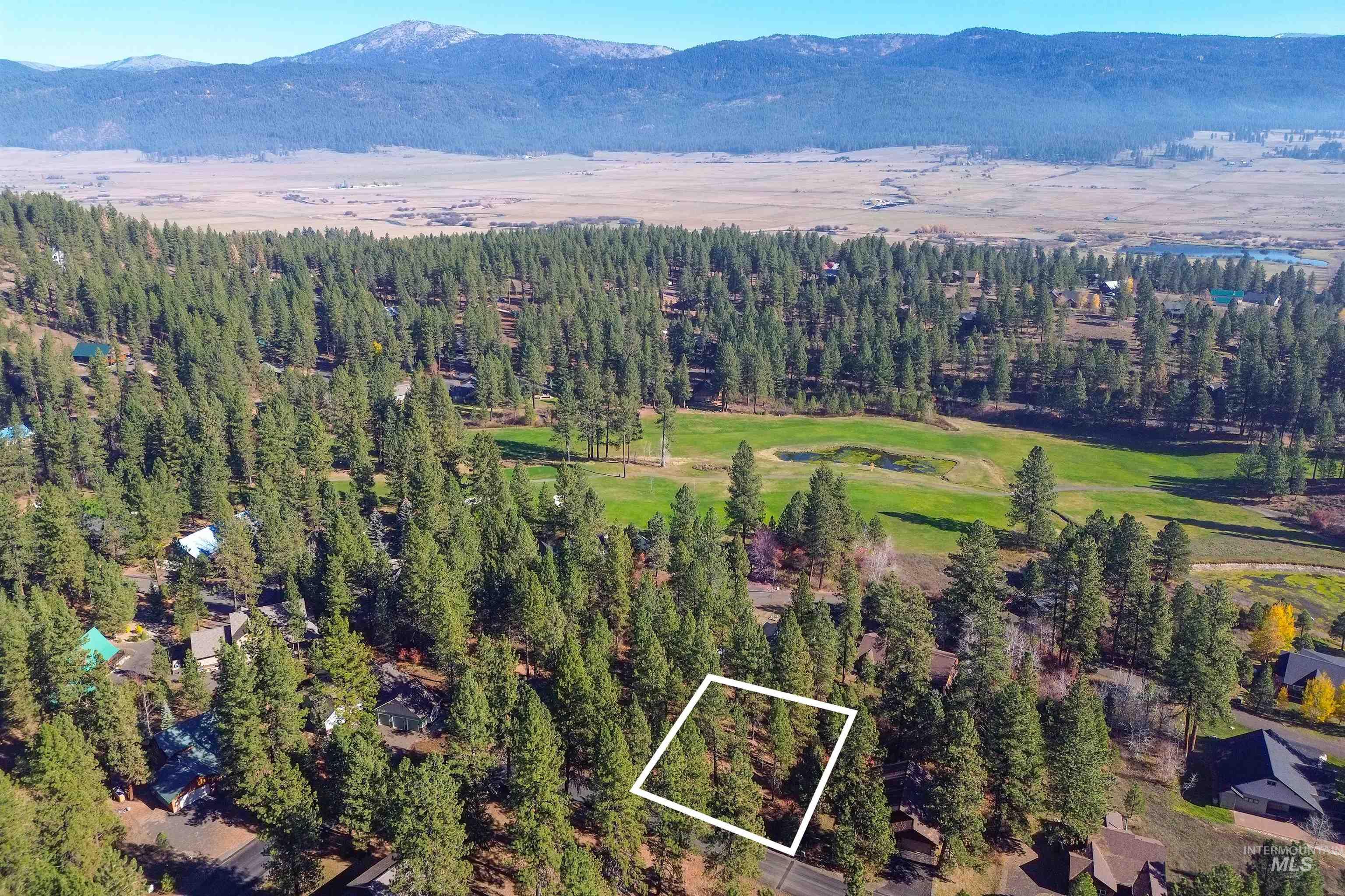 Aerial view of property's location with property boundaries highlighted and a mountainous background