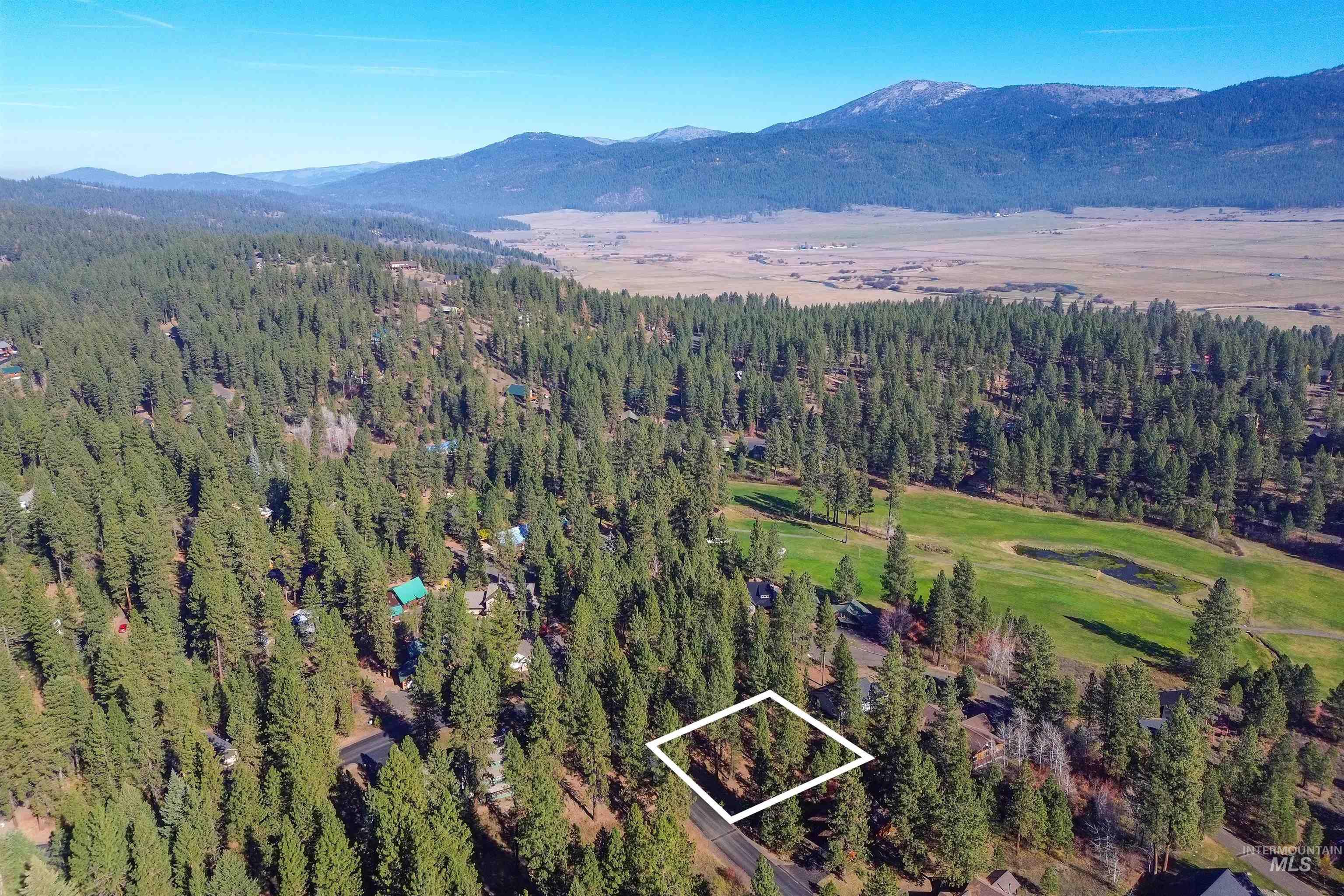 Aerial view of property and surrounding area featuring property boundaries highlighted and mountains
