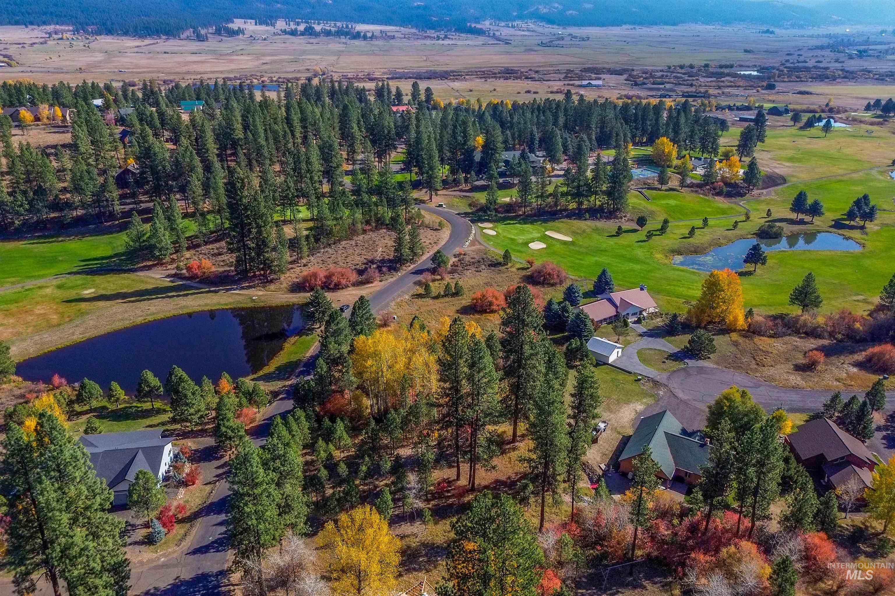 Aerial view of property and surrounding area with a nearby body of water and a golf club