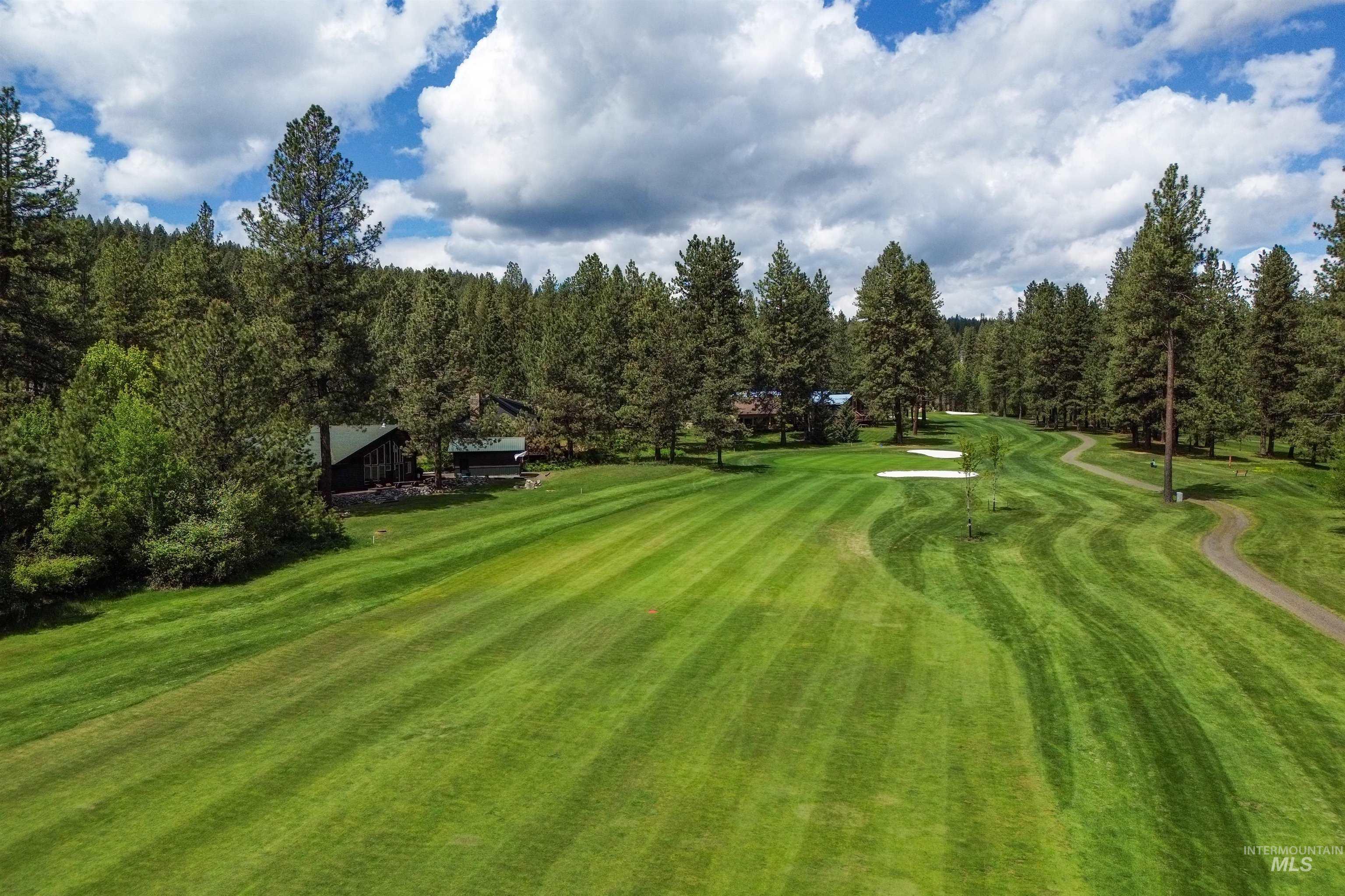 View of home's community with a yard and view of golf course