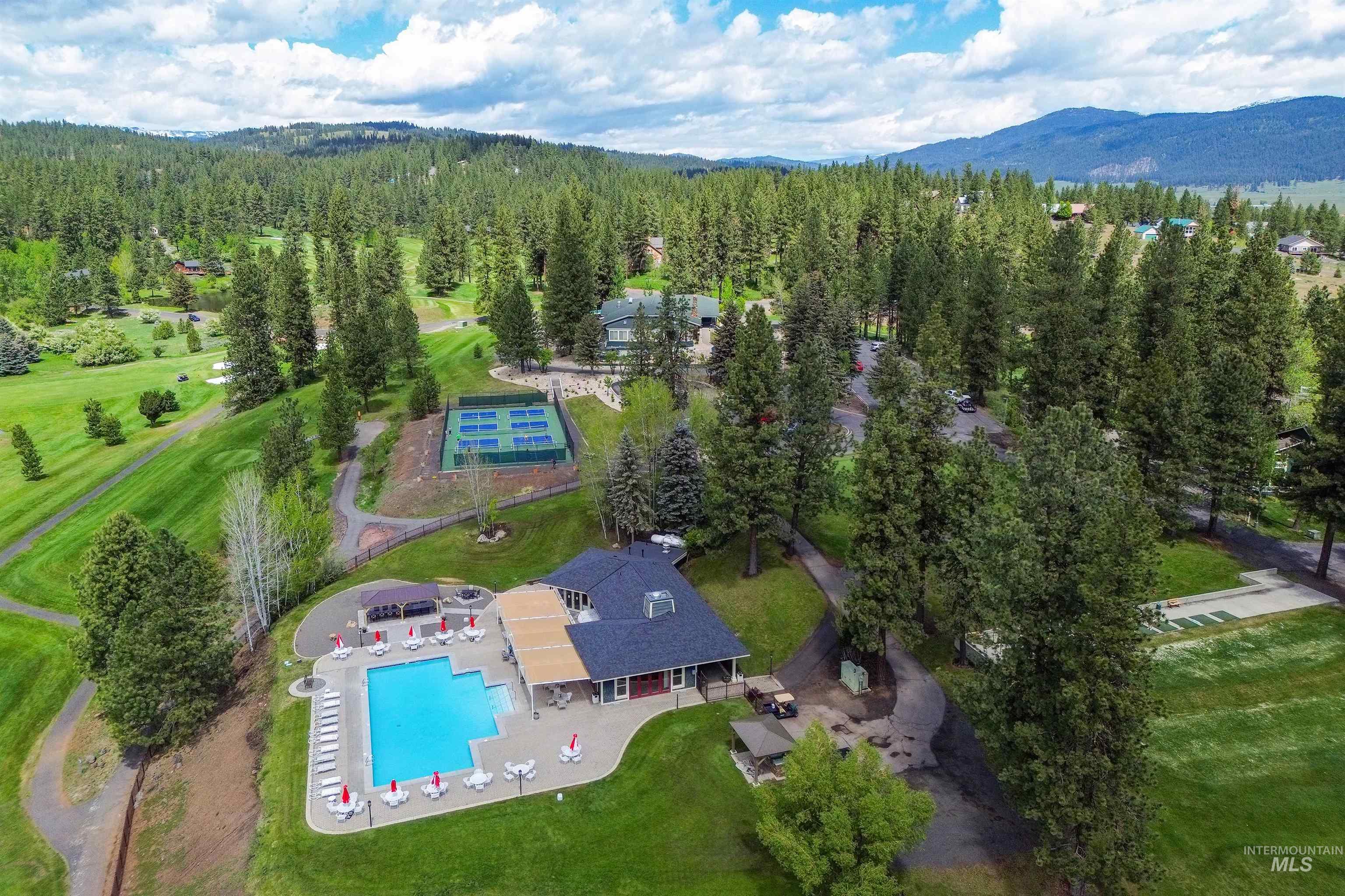Aerial view of property's location featuring a pool area and a mountain backdrop