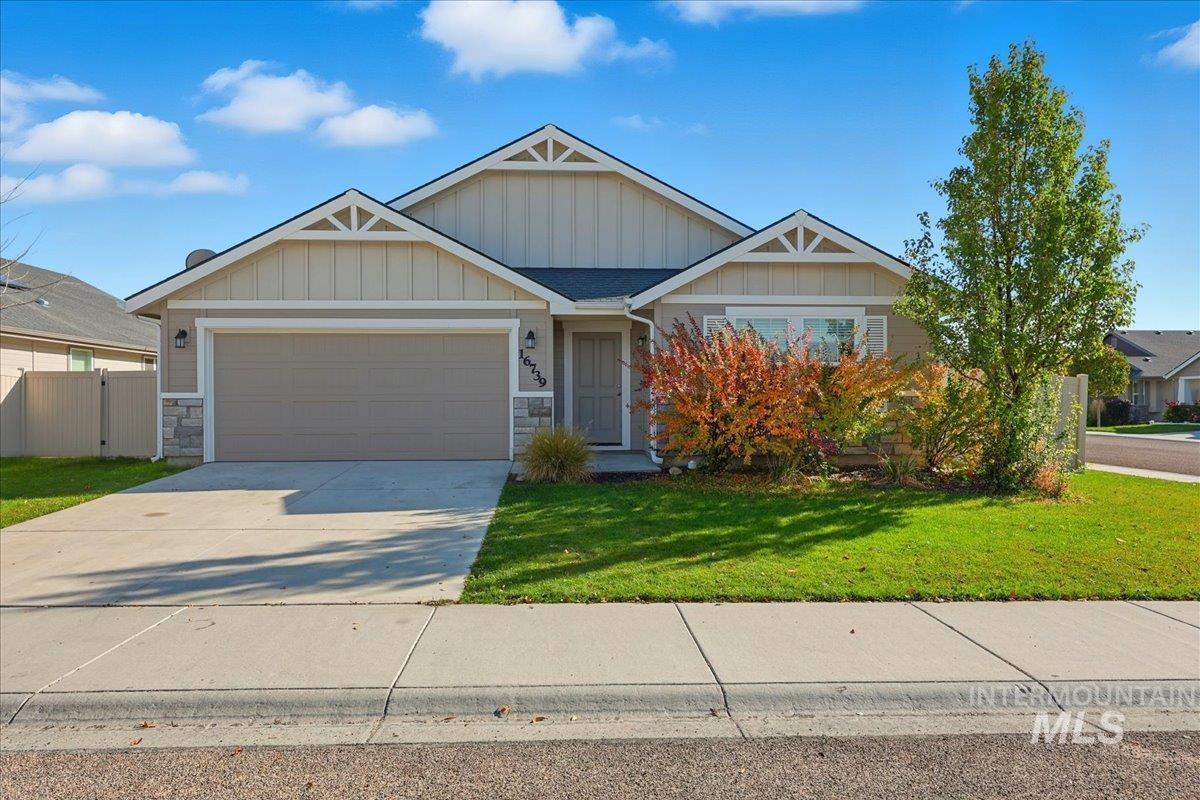Craftsman-style home with a garage, driveway, and stone siding
