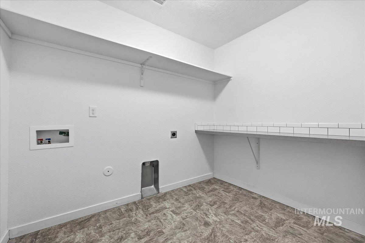 Washroom featuring gas dryer hookup, hookup for a washing machine, hookup for an electric dryer, a textured ceiling, and light carpet