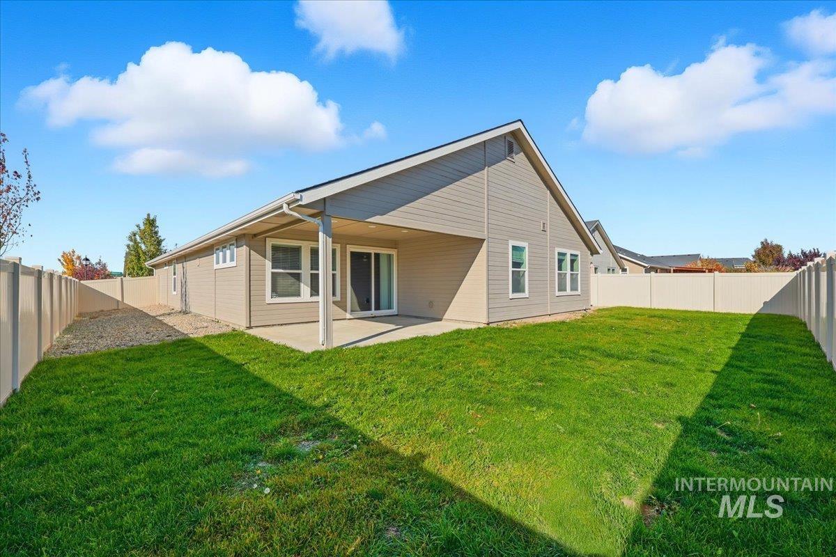 Back of property with a fenced backyard and a patio