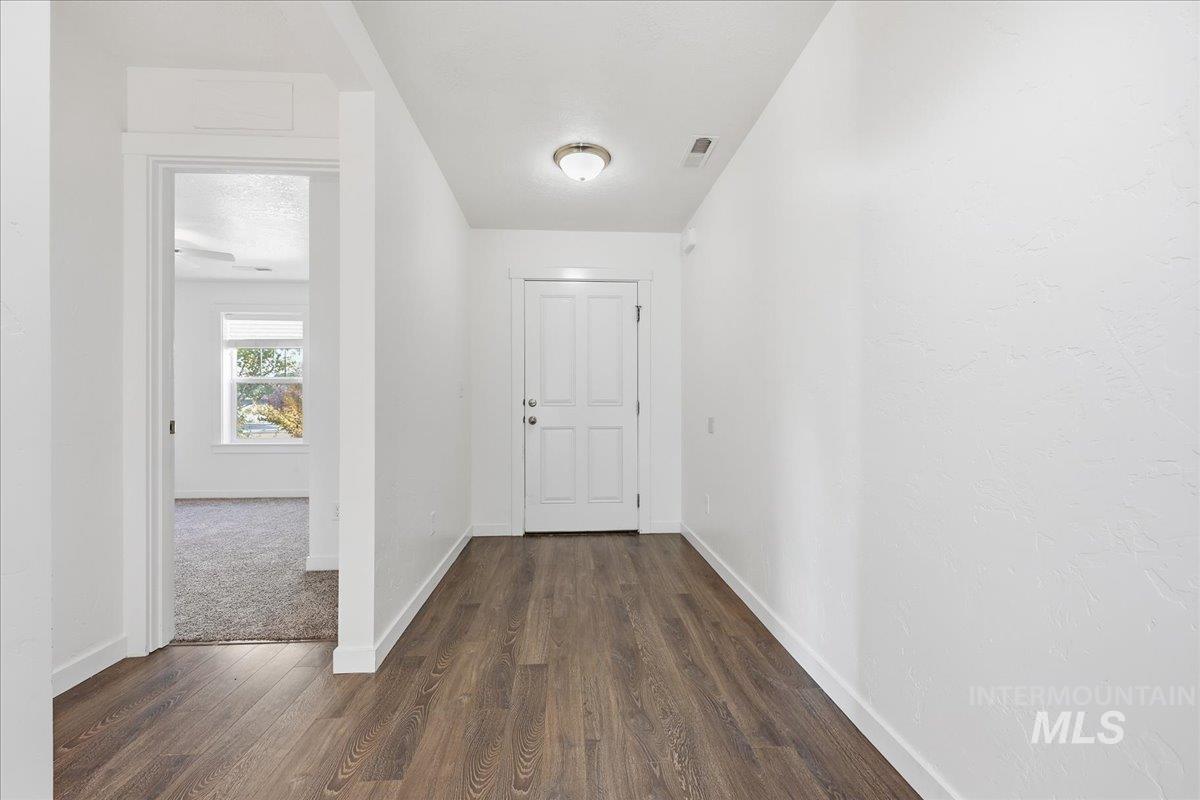 Hallway with baseboards and dark wood-style floors