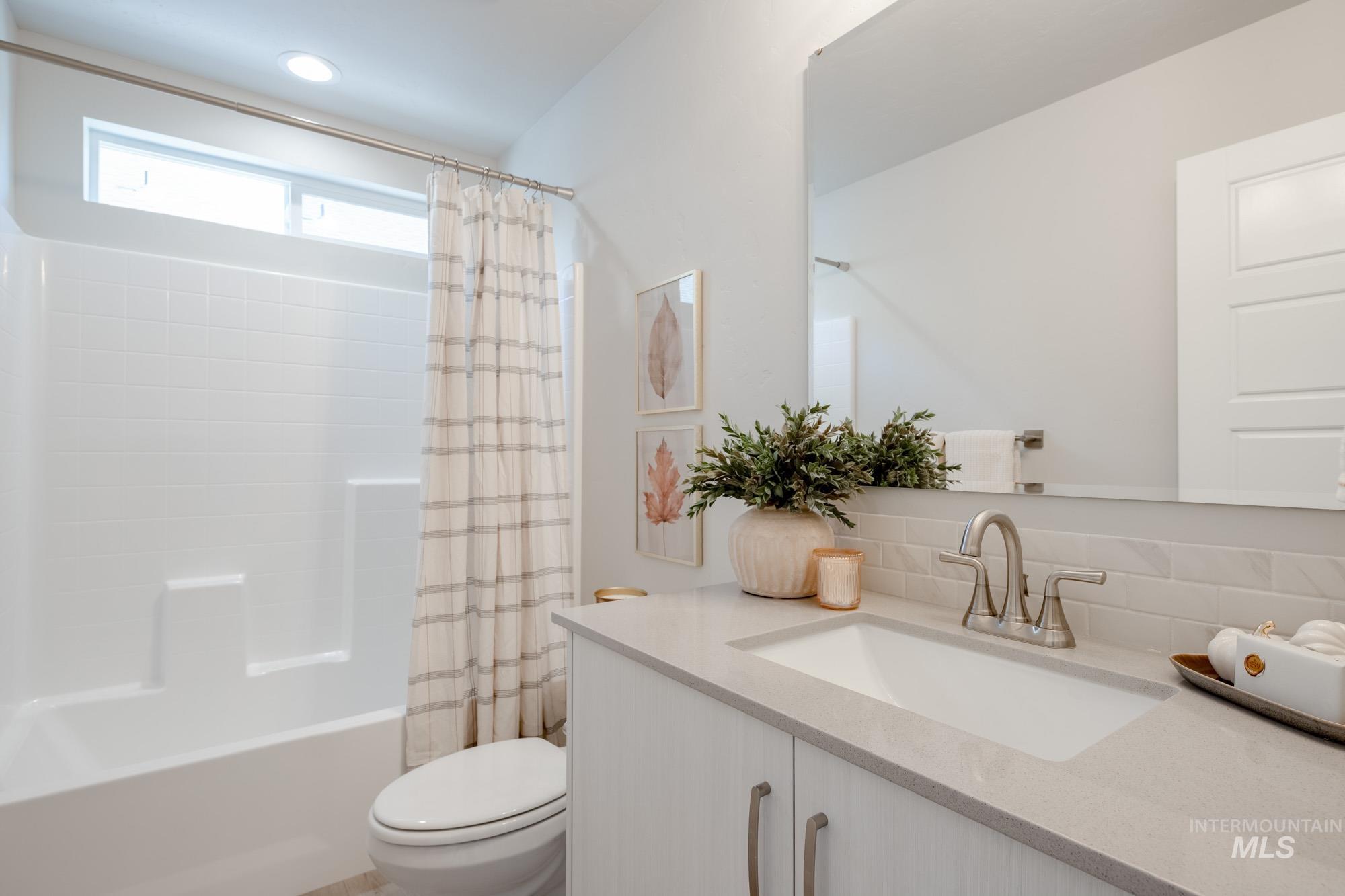 Full bathroom featuring vanity, shower / bathtub combination with curtain, and decorative backsplash