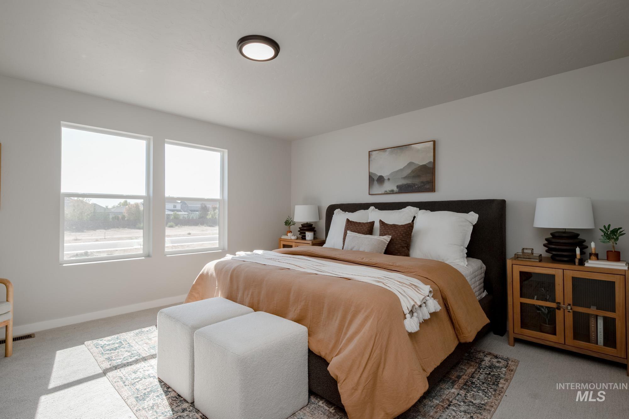 Bedroom with light colored carpet and baseboards