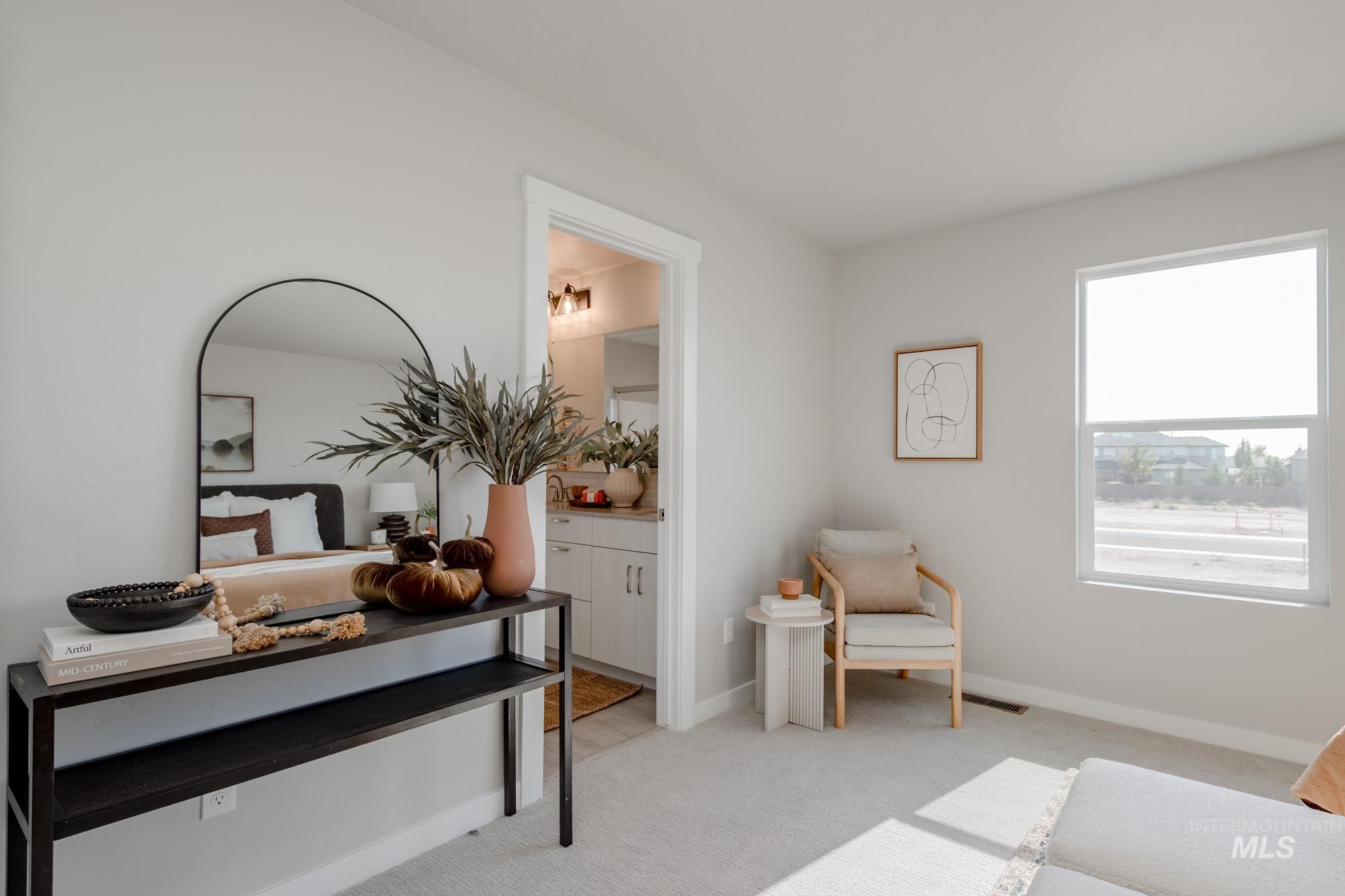 Living area with light colored carpet and baseboards