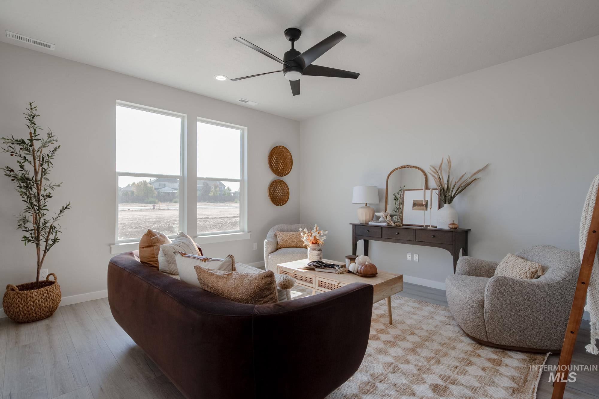 Living area with light wood-style floors and a ceiling fan