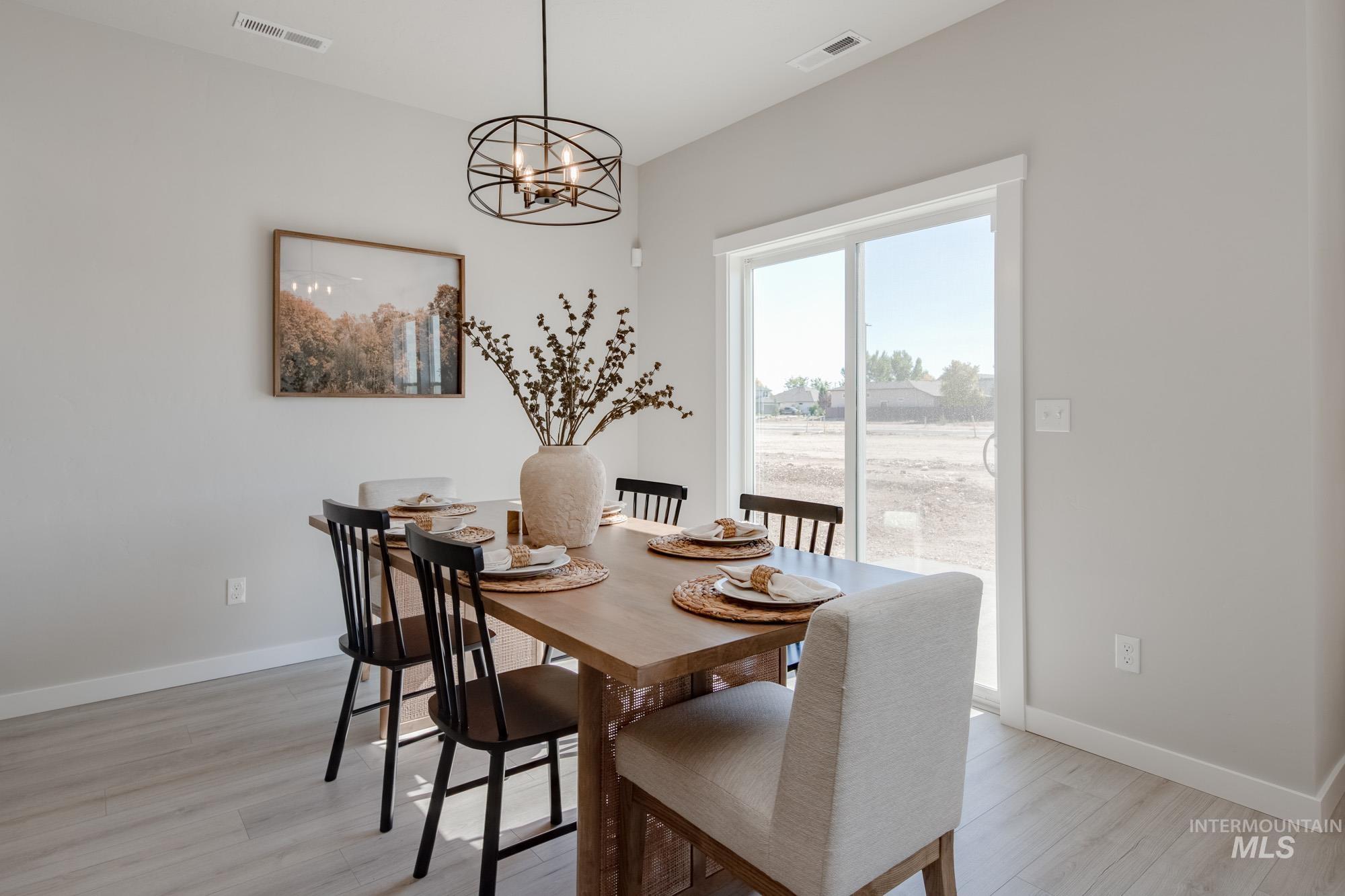 Dining room featuring light wood-style floors and a chandelier