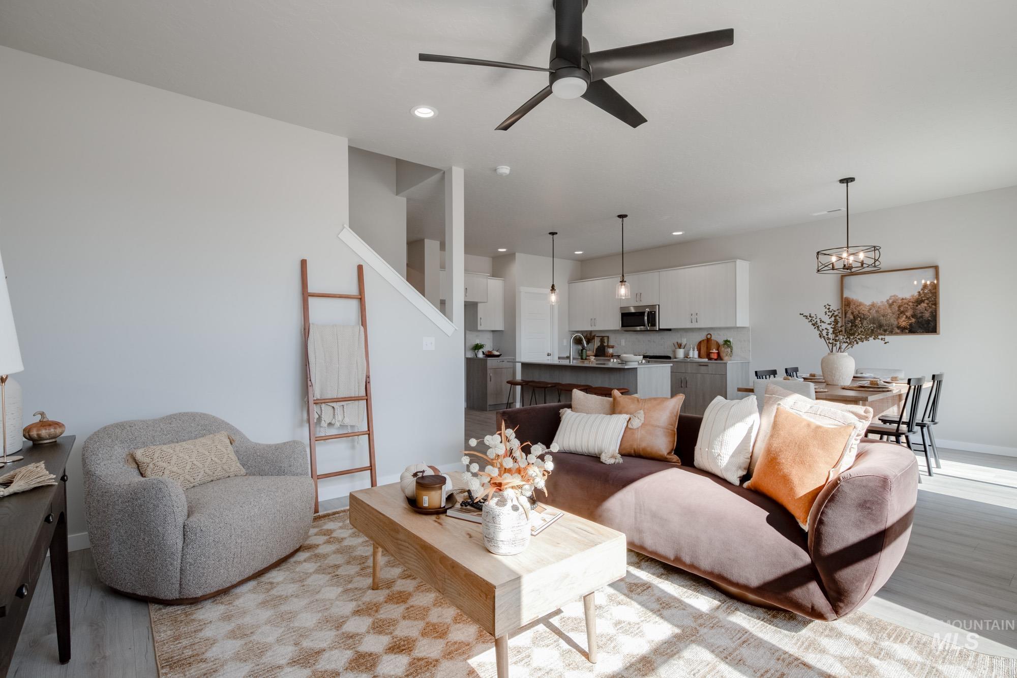 Living room with light wood-style flooring, ceiling fan, recessed lighting, and a chandelier