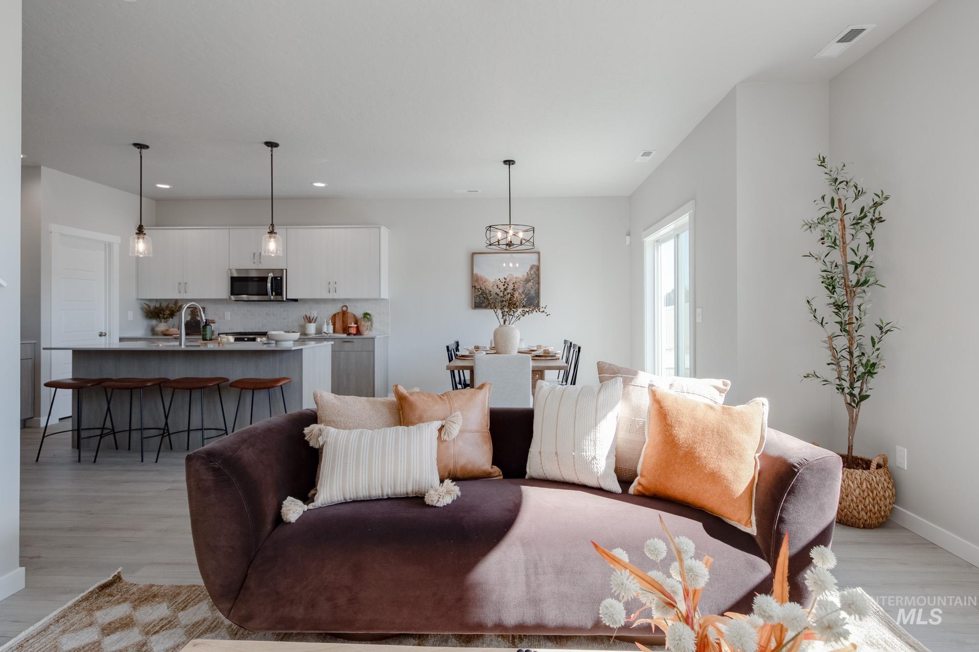 Living area featuring light wood-type flooring, recessed lighting, and a chandelier
