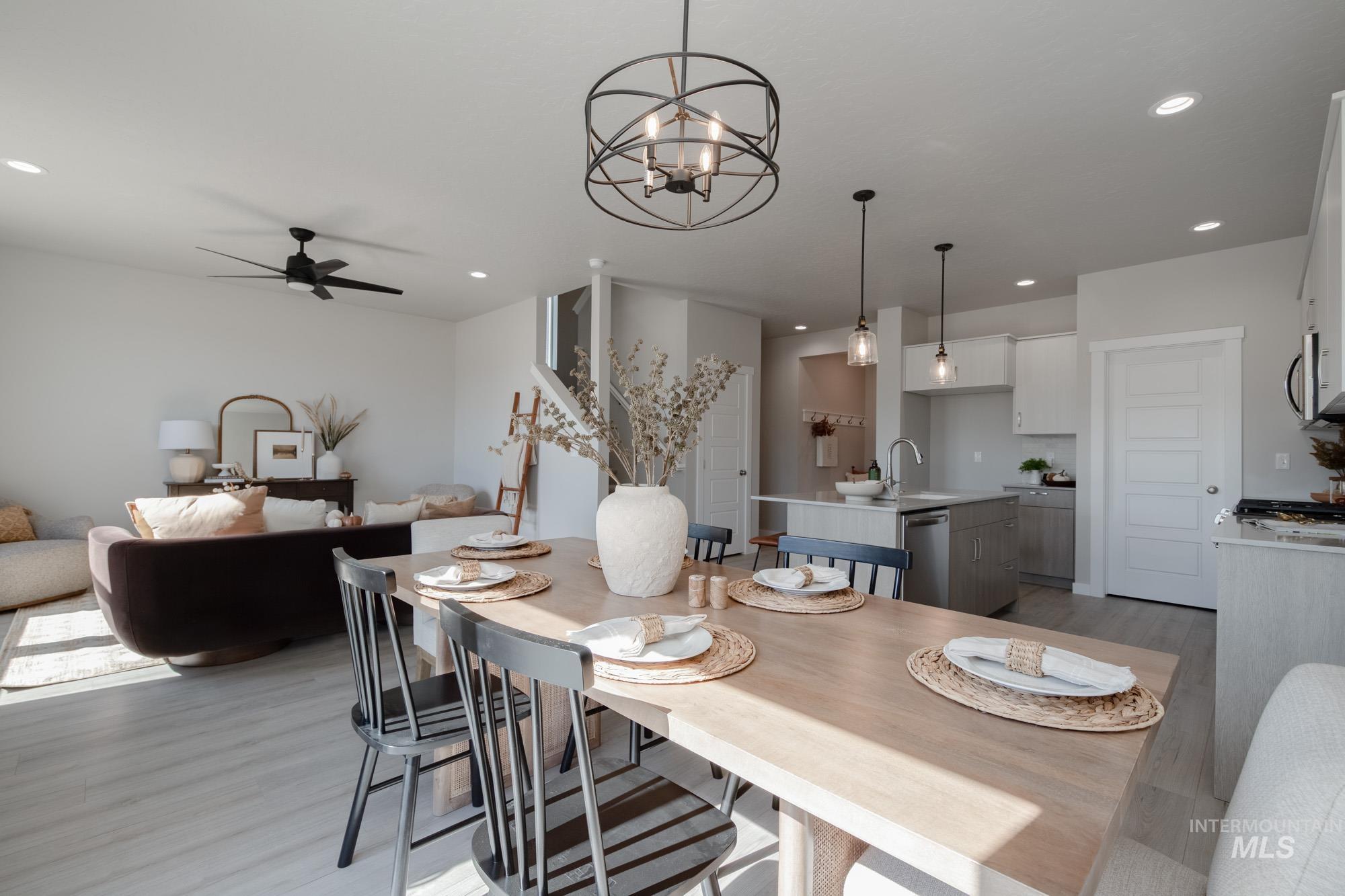 Dining space featuring light wood-type flooring, ceiling fan, recessed lighting, and a chandelier