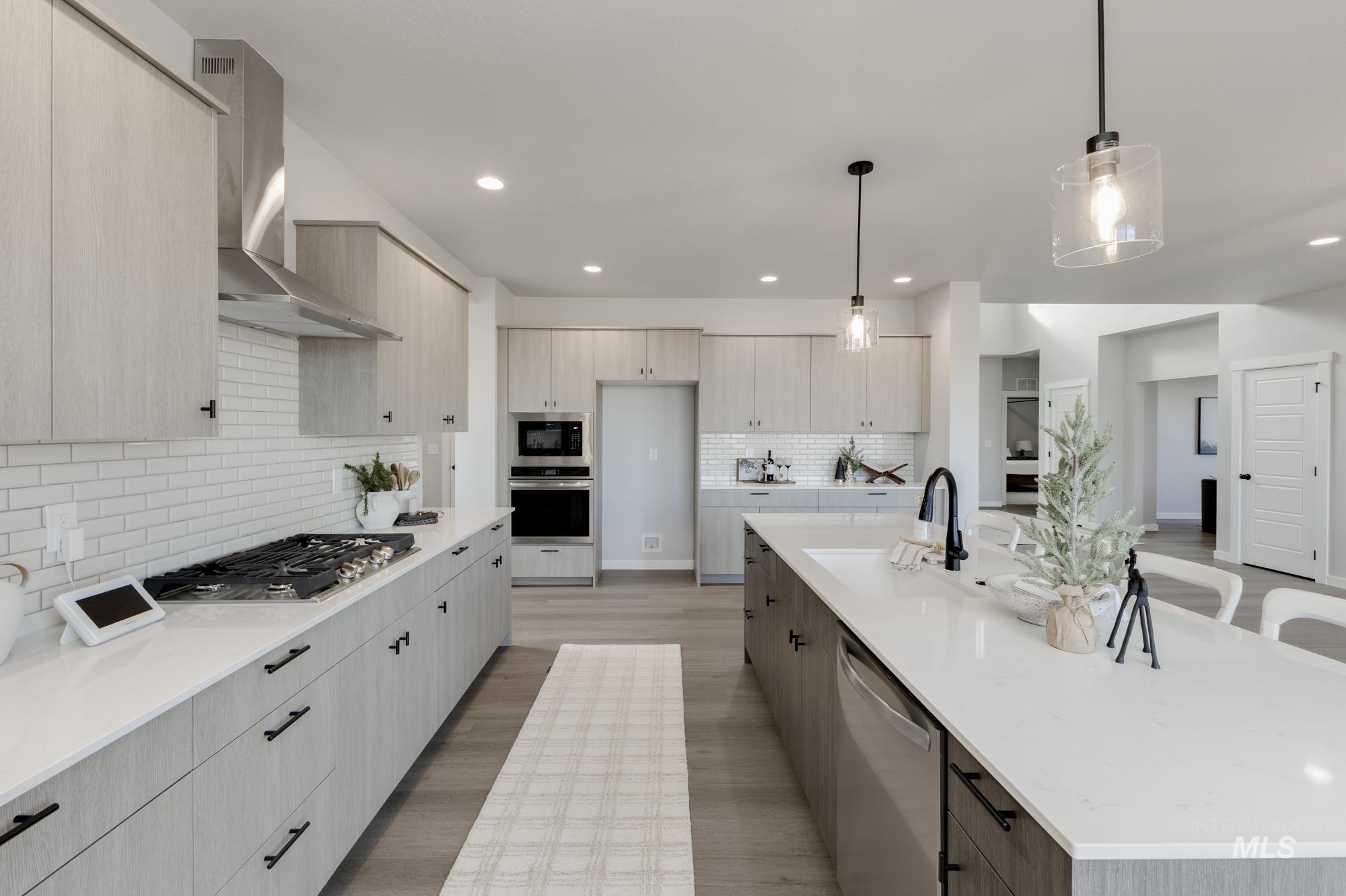 Kitchen featuring modern cabinets, wall chimney exhaust hood, pendant lighting, backsplash, and recessed lighting