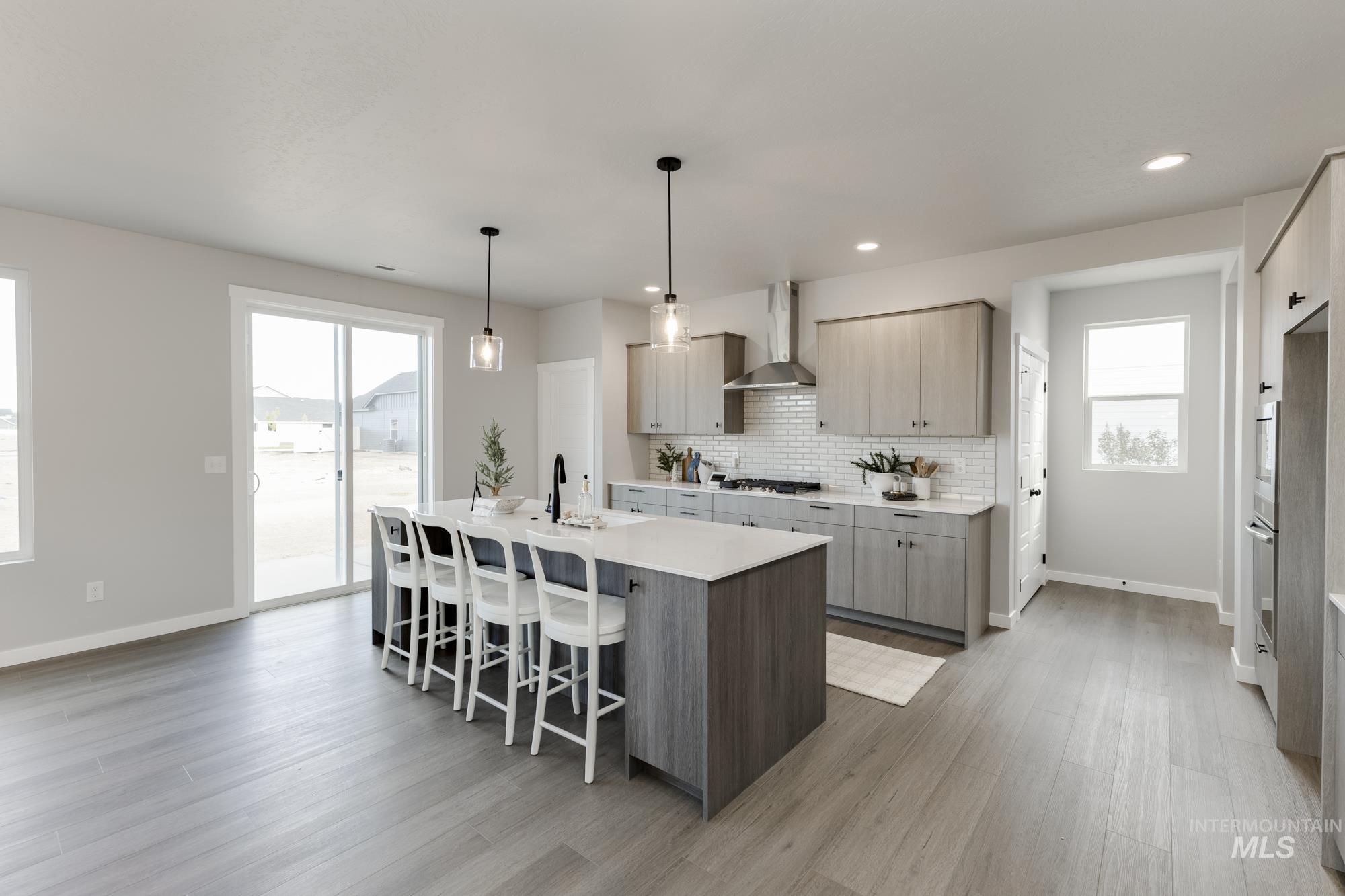 Kitchen with a breakfast bar, a center island with sink, tasteful backsplash, light wood-style flooring, and recessed lighting
