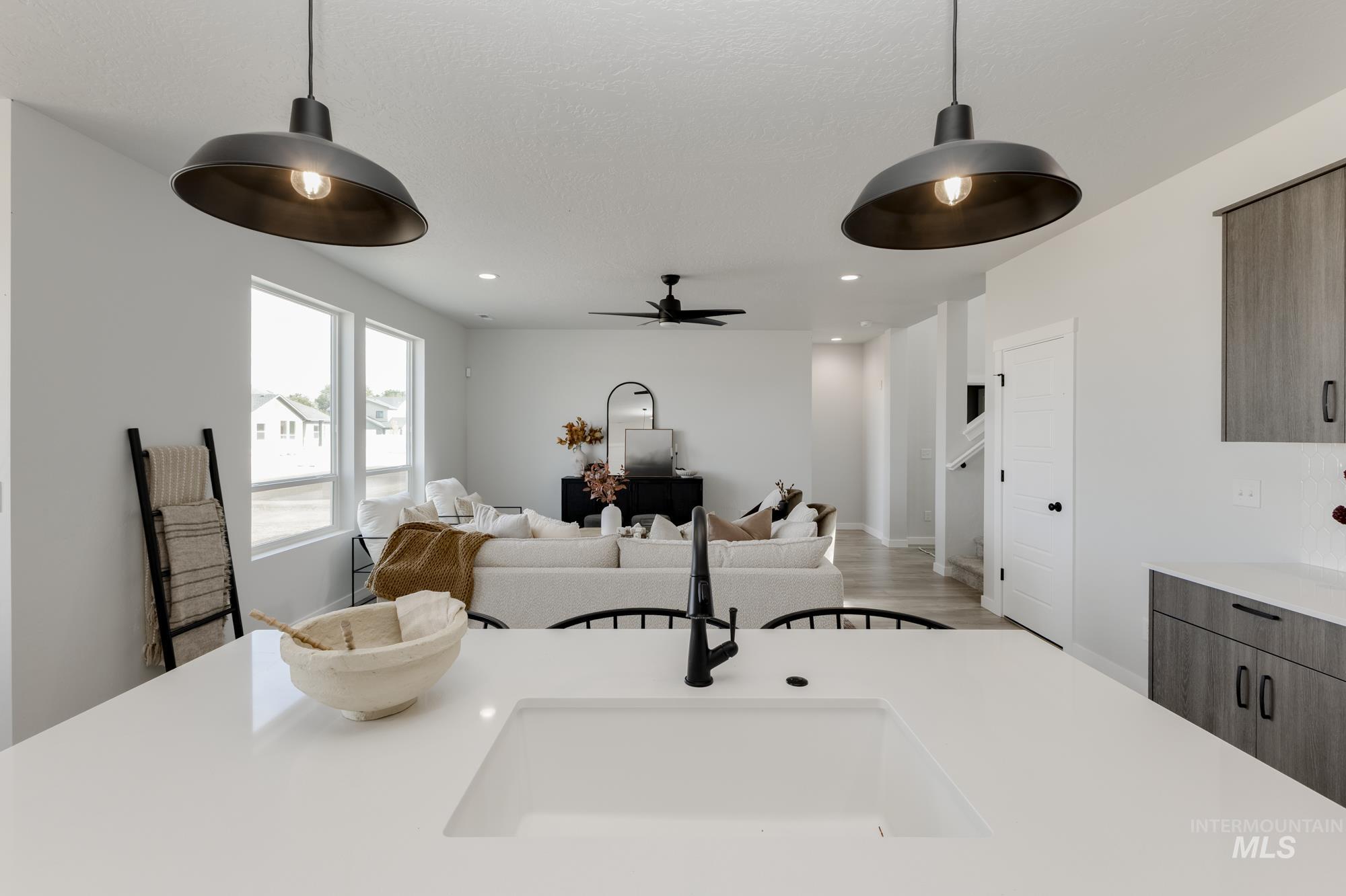 Kitchen view of recessed lighting, hanging light fixtures, modern cabinets, wood finished floors, and a ceiling fan