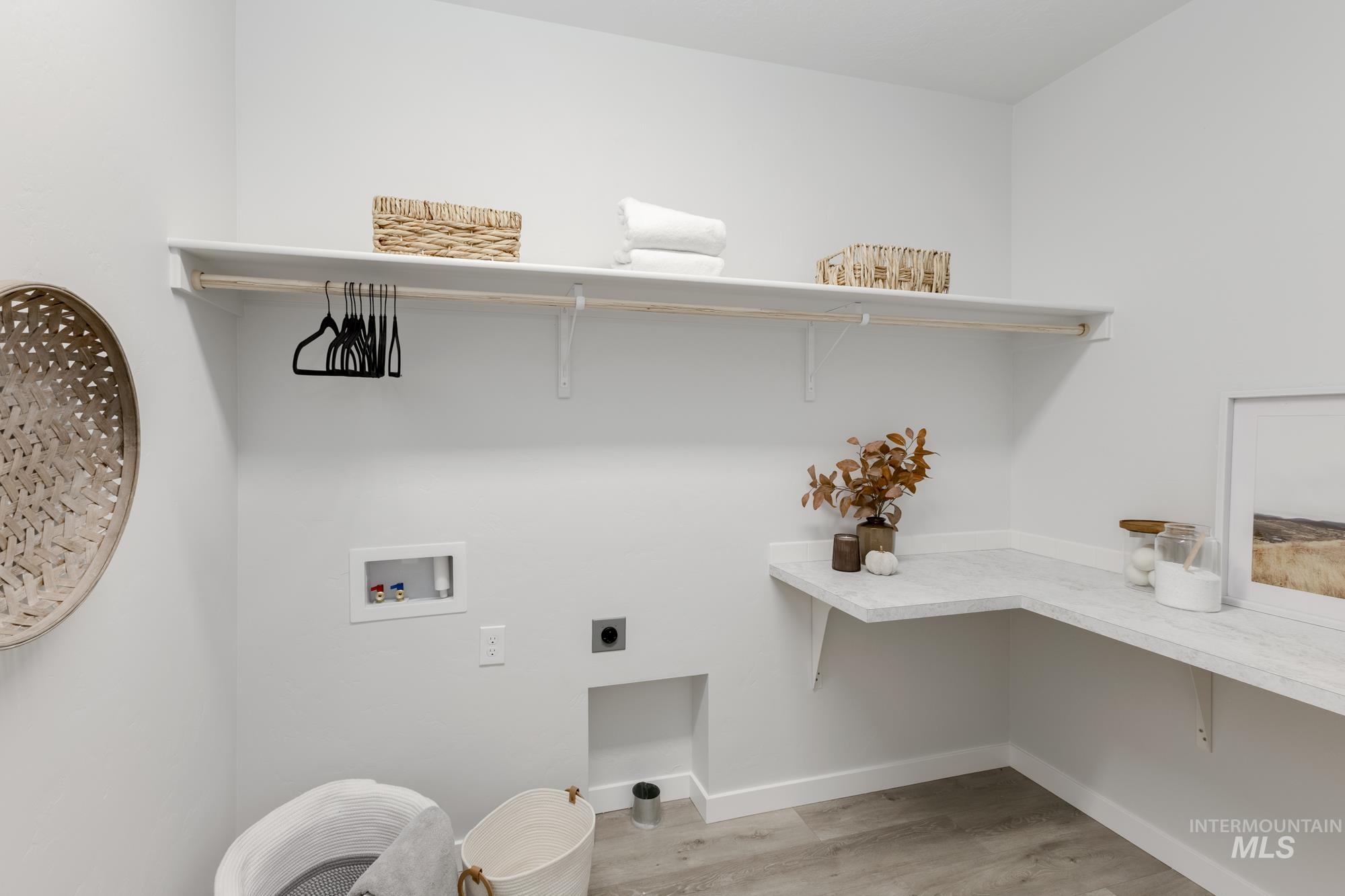 Washroom featuring hookup for a washing machine, electric dryer hookup, and light wood-type flooring