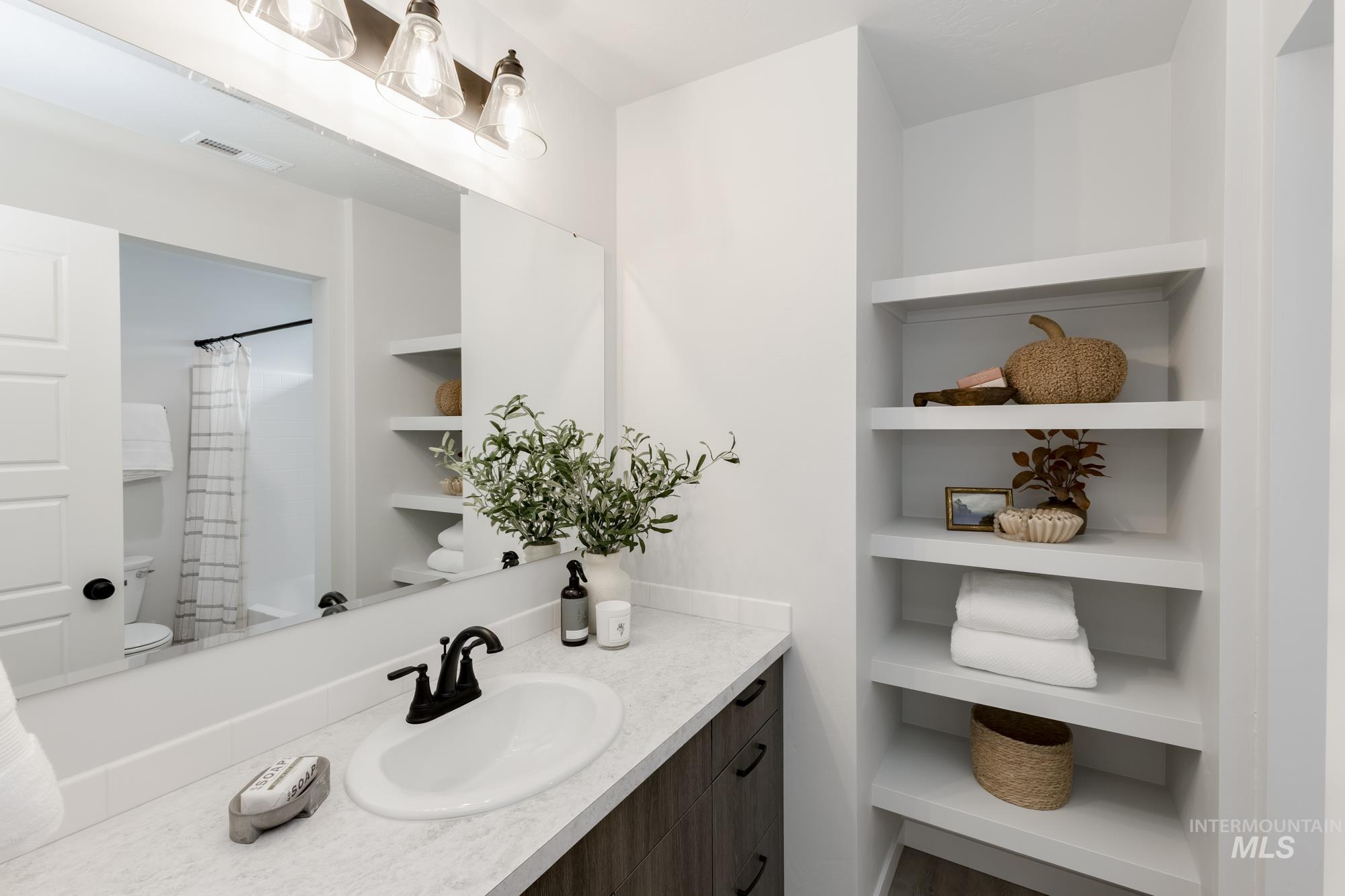 Bathroom featuring vanity, curtained shower, and built in features