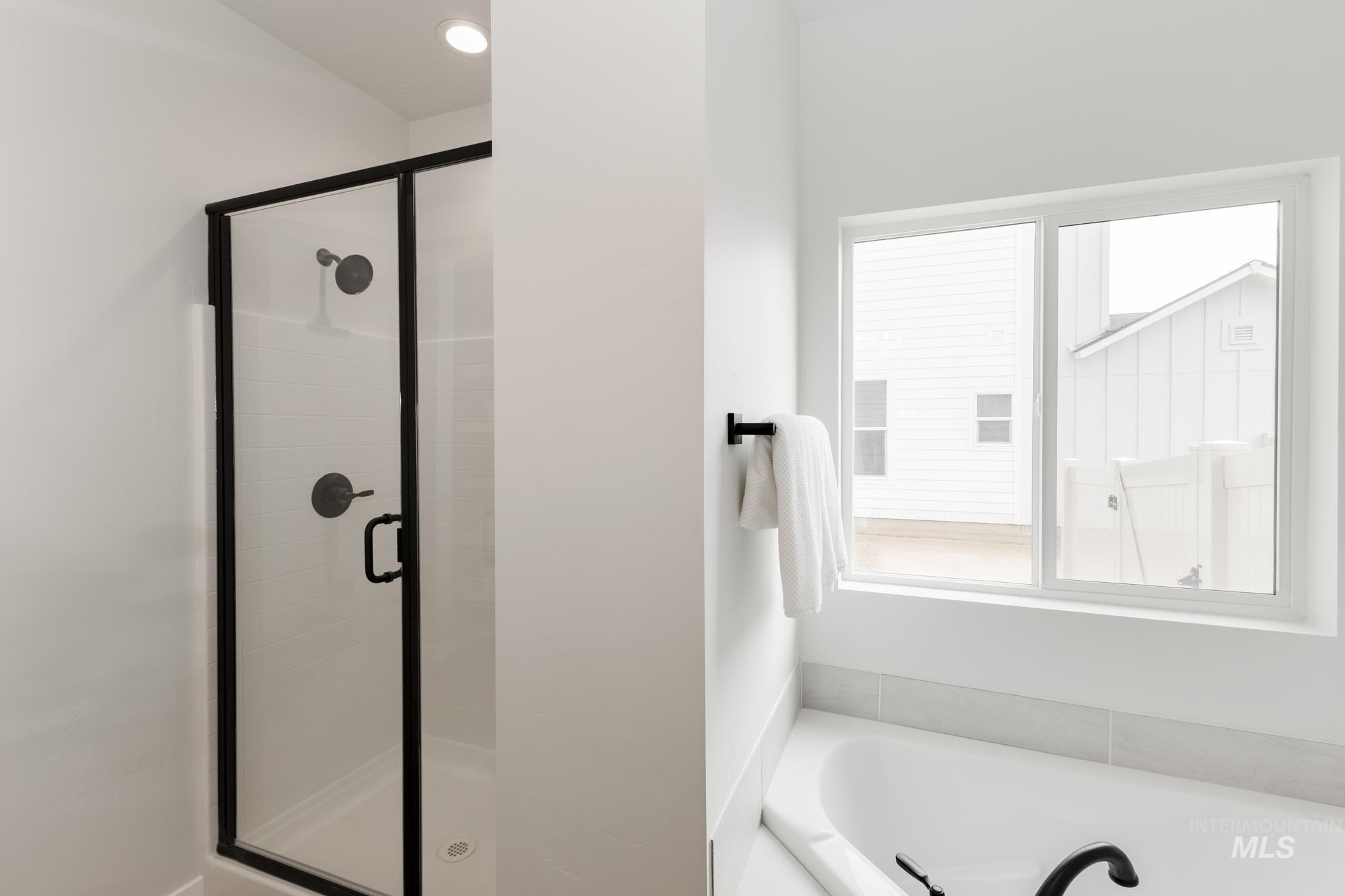 Full bath featuring a shower stall and a garden tub