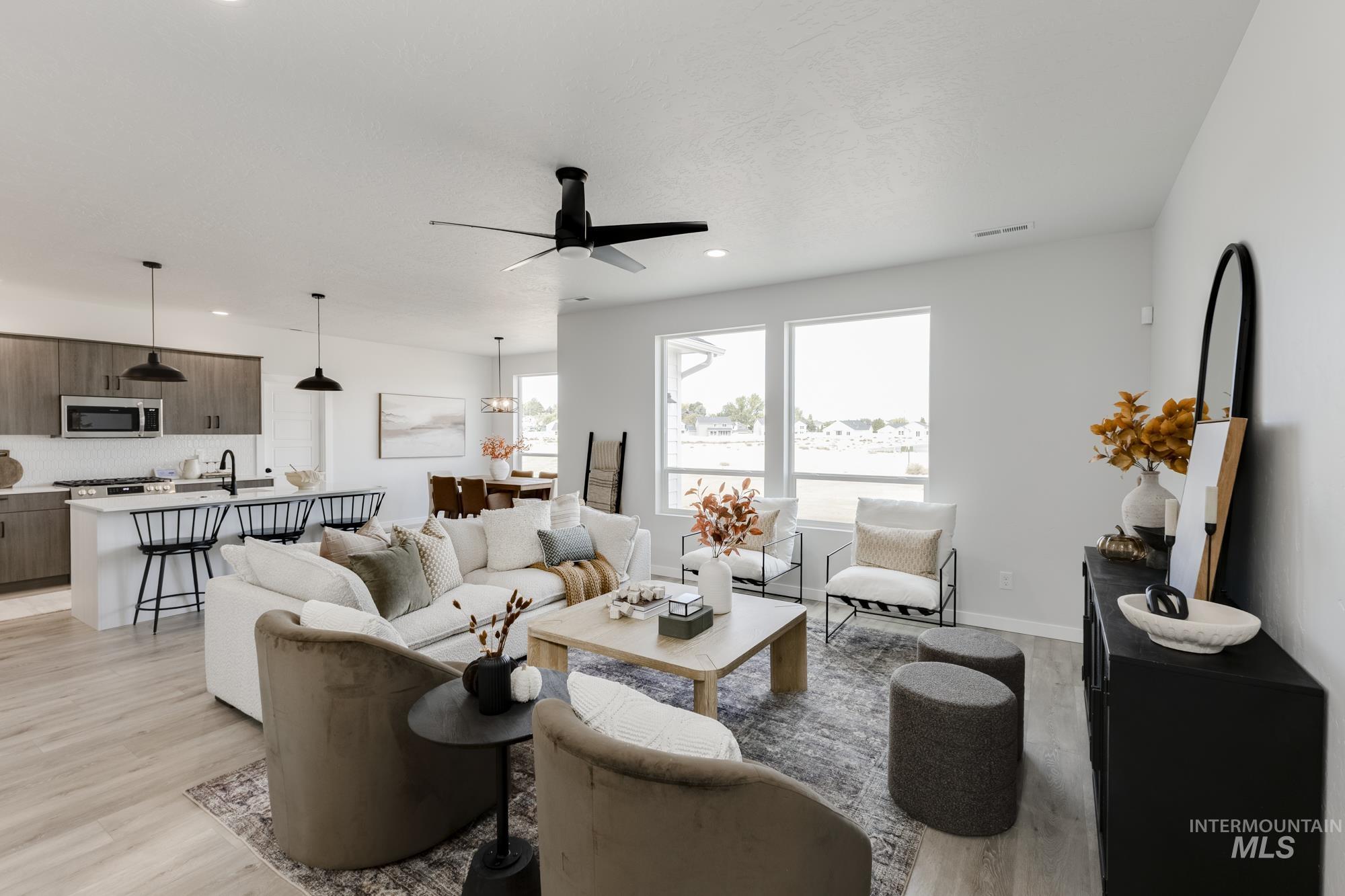 Living room with light wood-style flooring, a ceiling fan, and recessed lighting