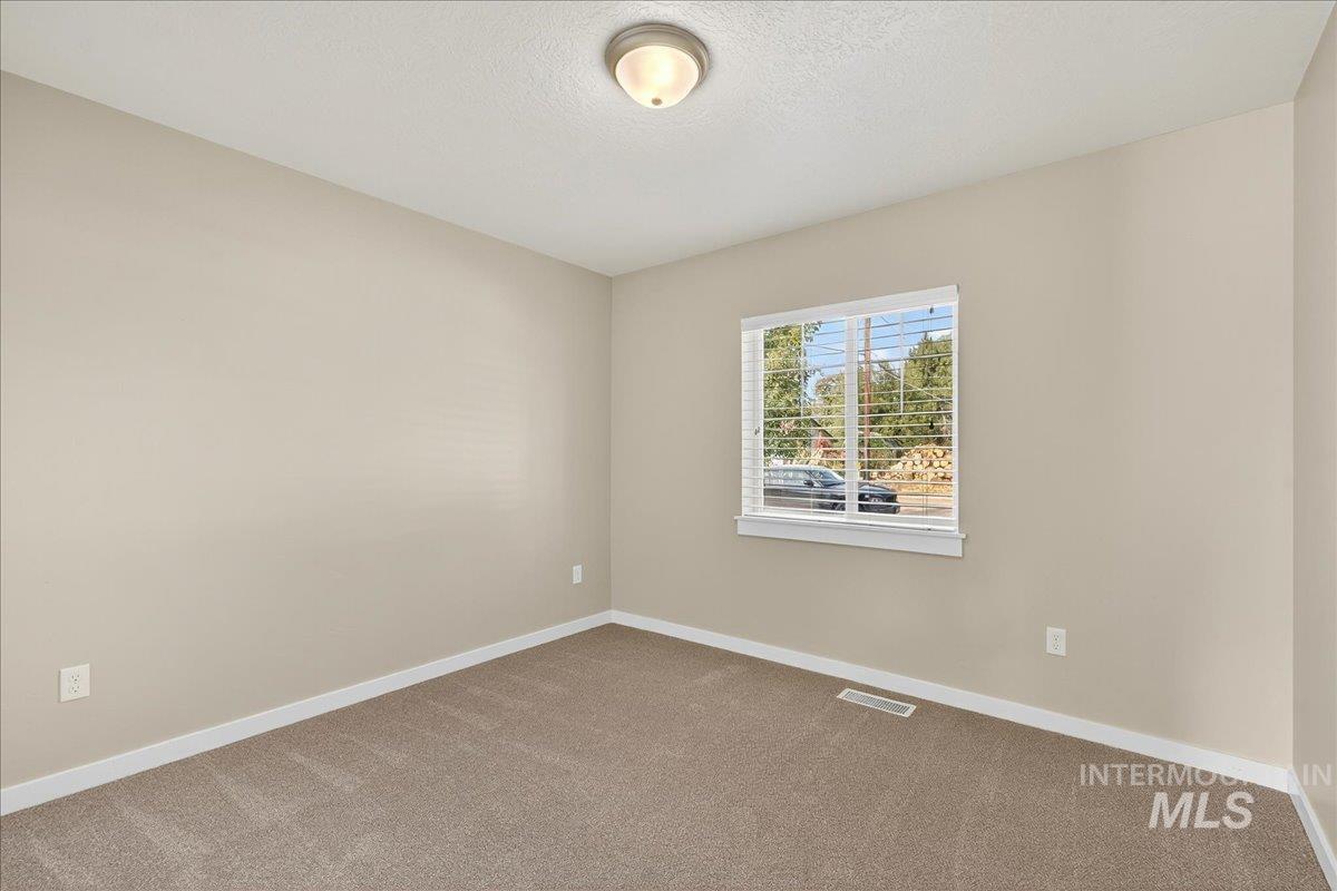 Unfurnished room featuring carpet and a textured ceiling