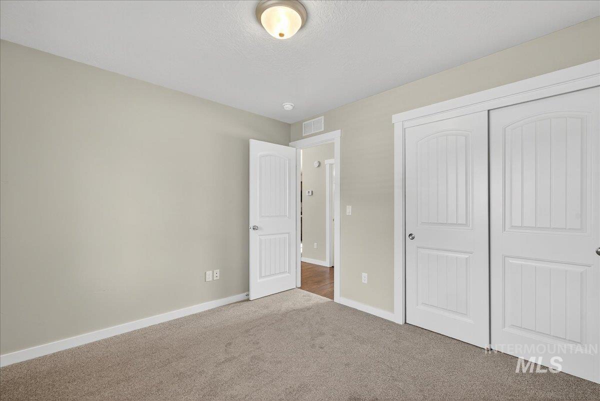 Unfurnished bedroom featuring carpet flooring, a closet, and a textured ceiling