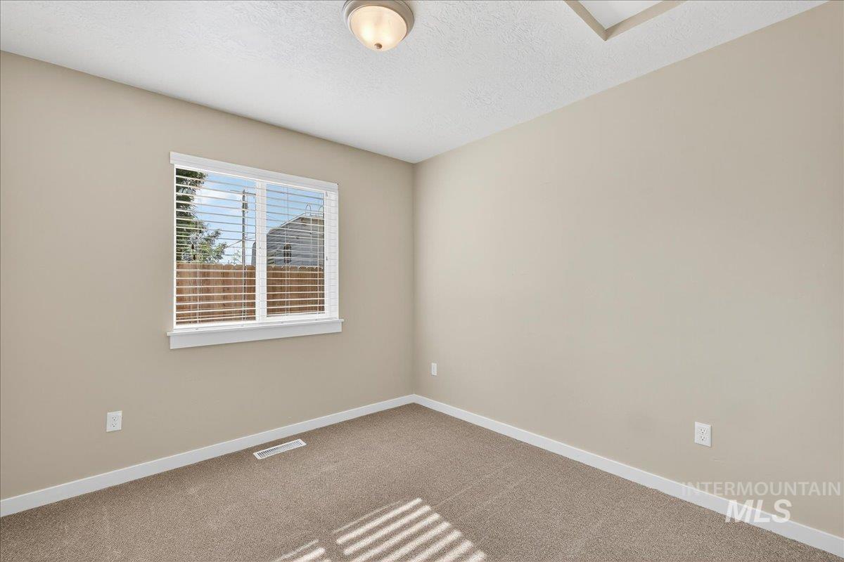 Unfurnished room featuring carpet and a textured ceiling