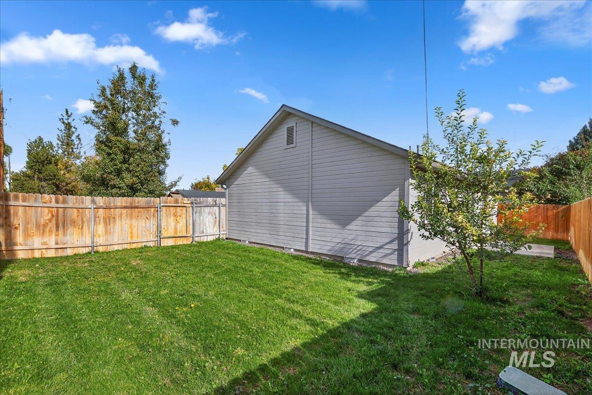 View of property exterior featuring a fenced backyard and an outdoor structure