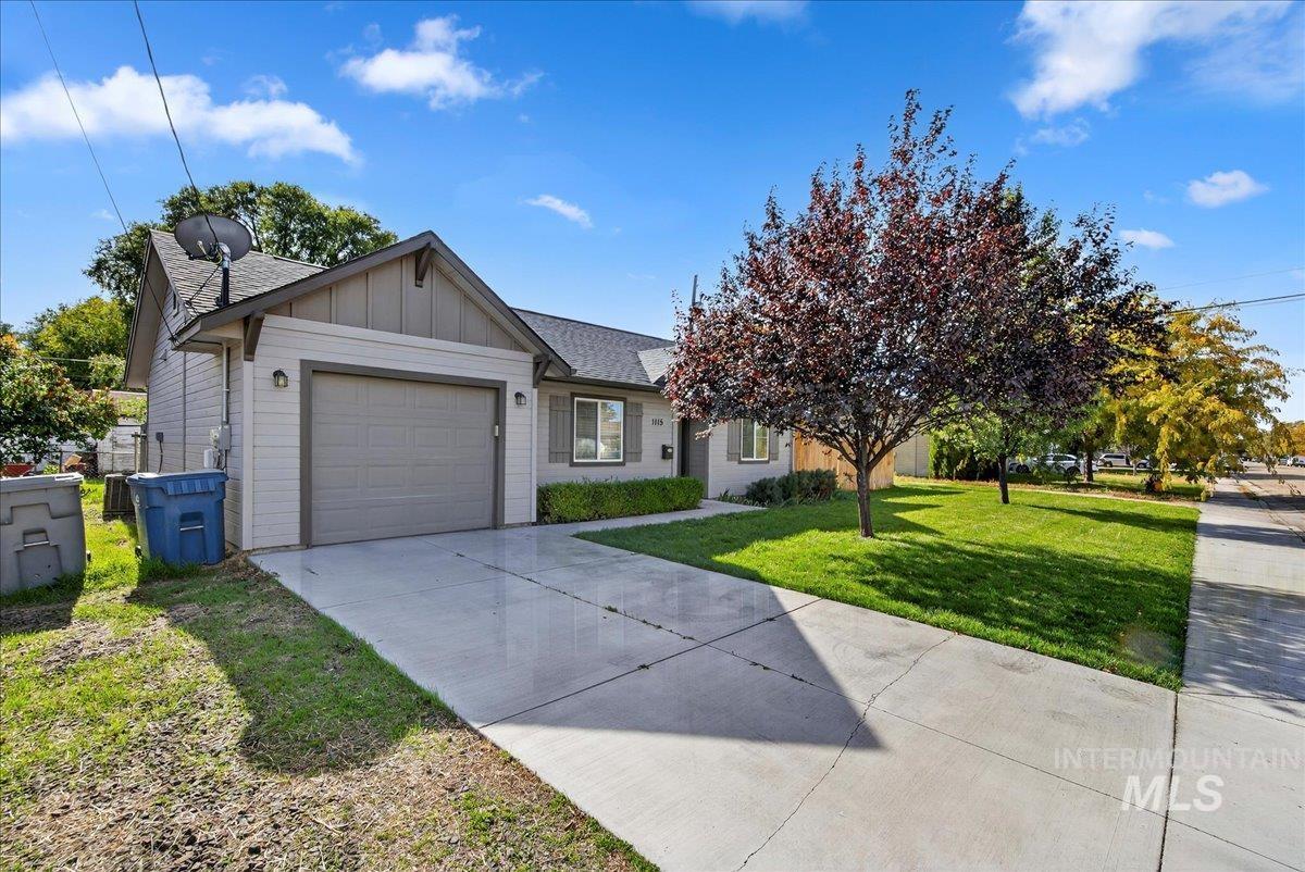 Ranch-style home featuring board and batten siding, a front yard, concrete driveway, an attached garage, and a shingled roof