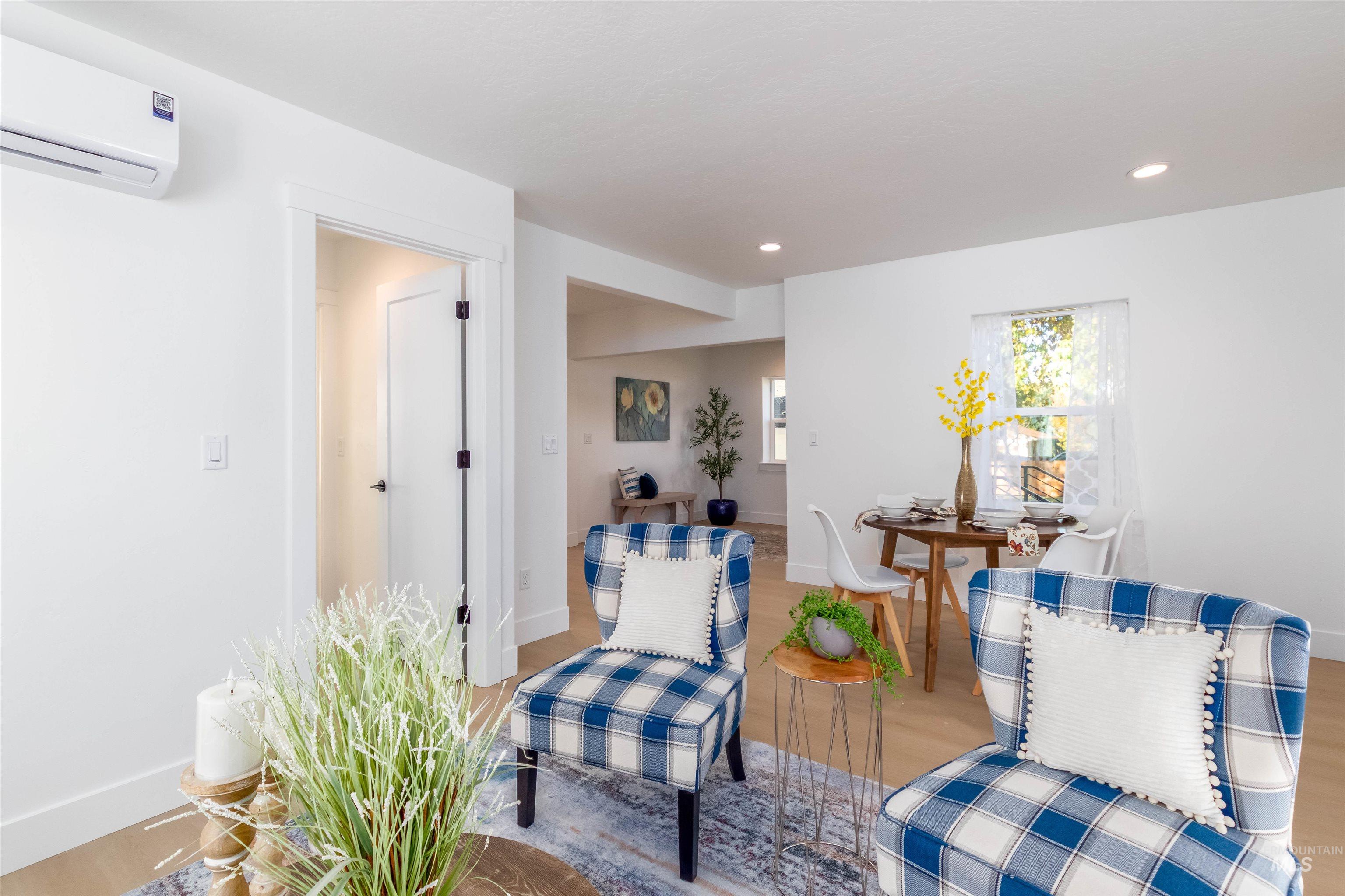 Sitting room featuring an AC wall unit, recessed lighting, and wood finished floors