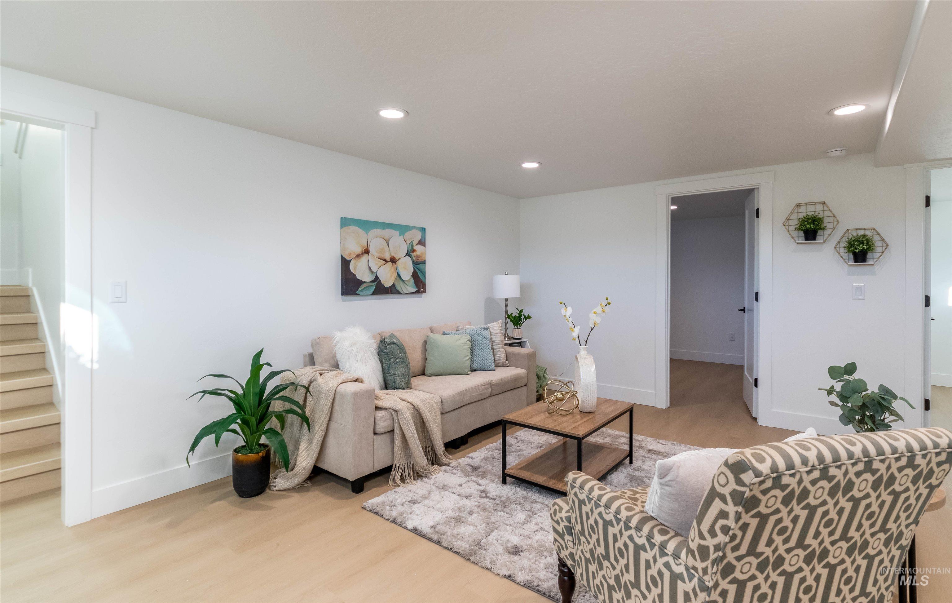 Living room featuring light wood-style floors, recessed lighting, and stairway