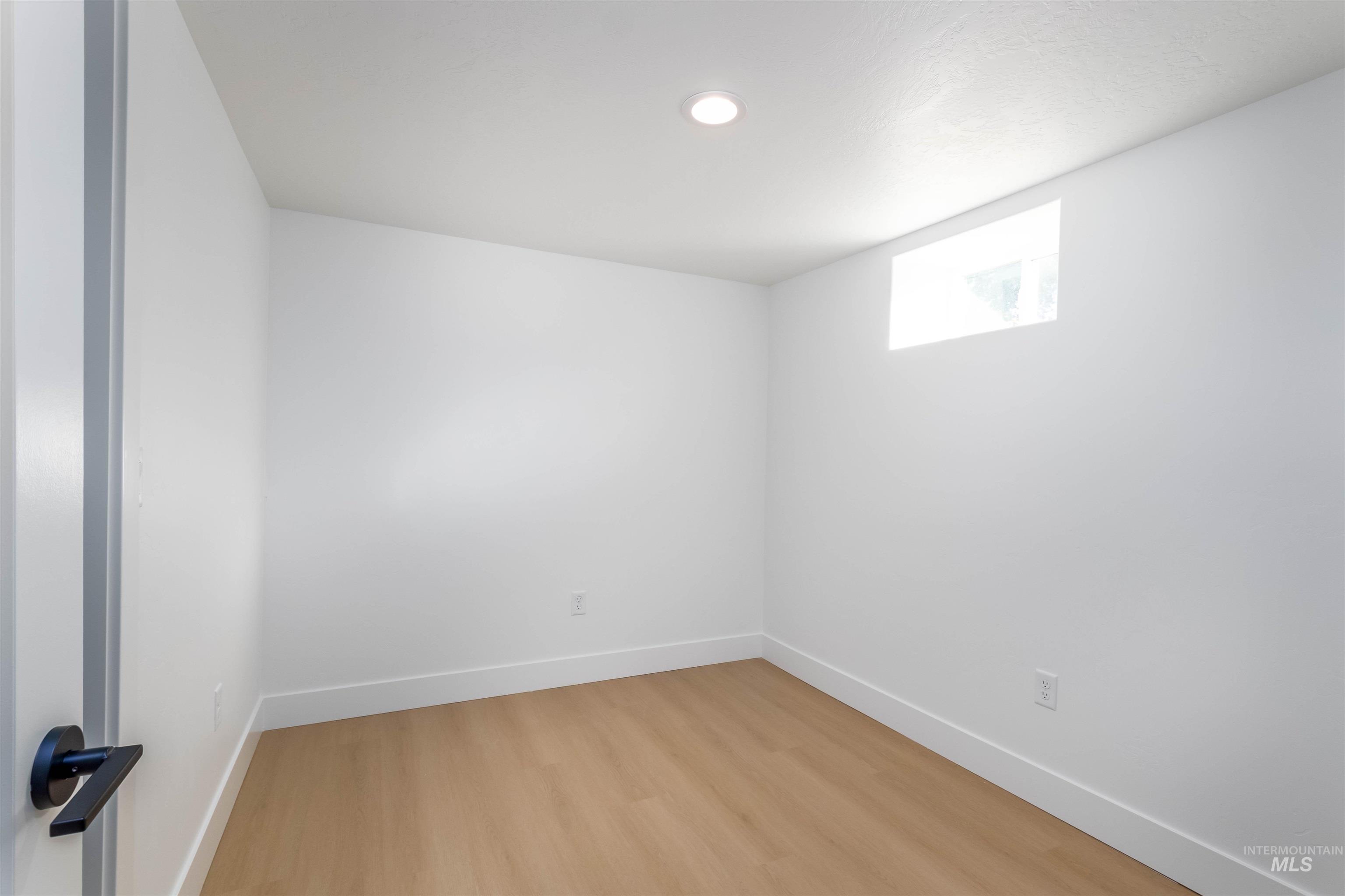 Spare room with wood finished floors and recessed lighting
